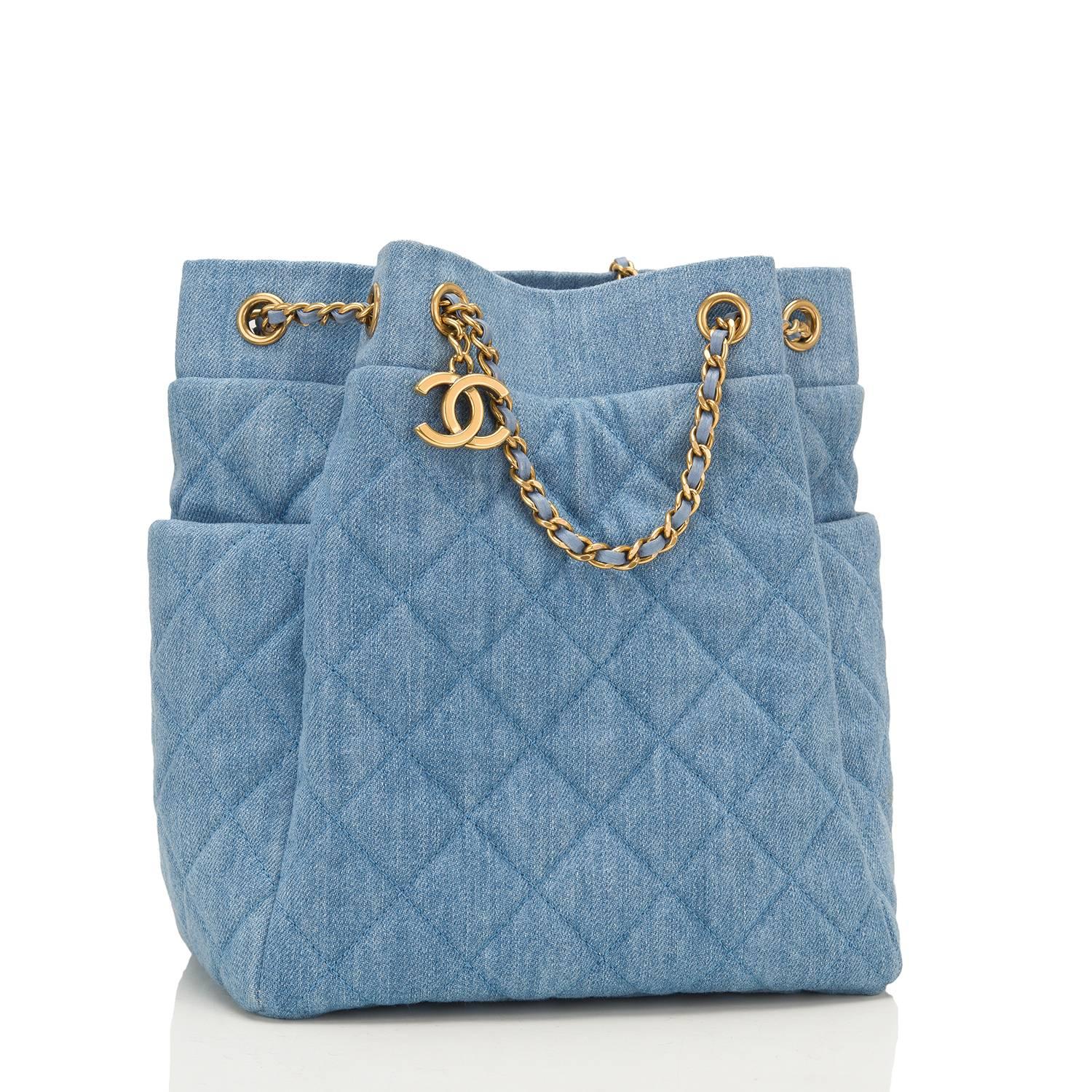 Chanel Drawstring Bag of light blue washed quilted denim and antique gold hardware.

This limited edition Chanel bag features two exterior side pockets and antique gold chain link and light blue leather padded shoulder strap.

The interior is