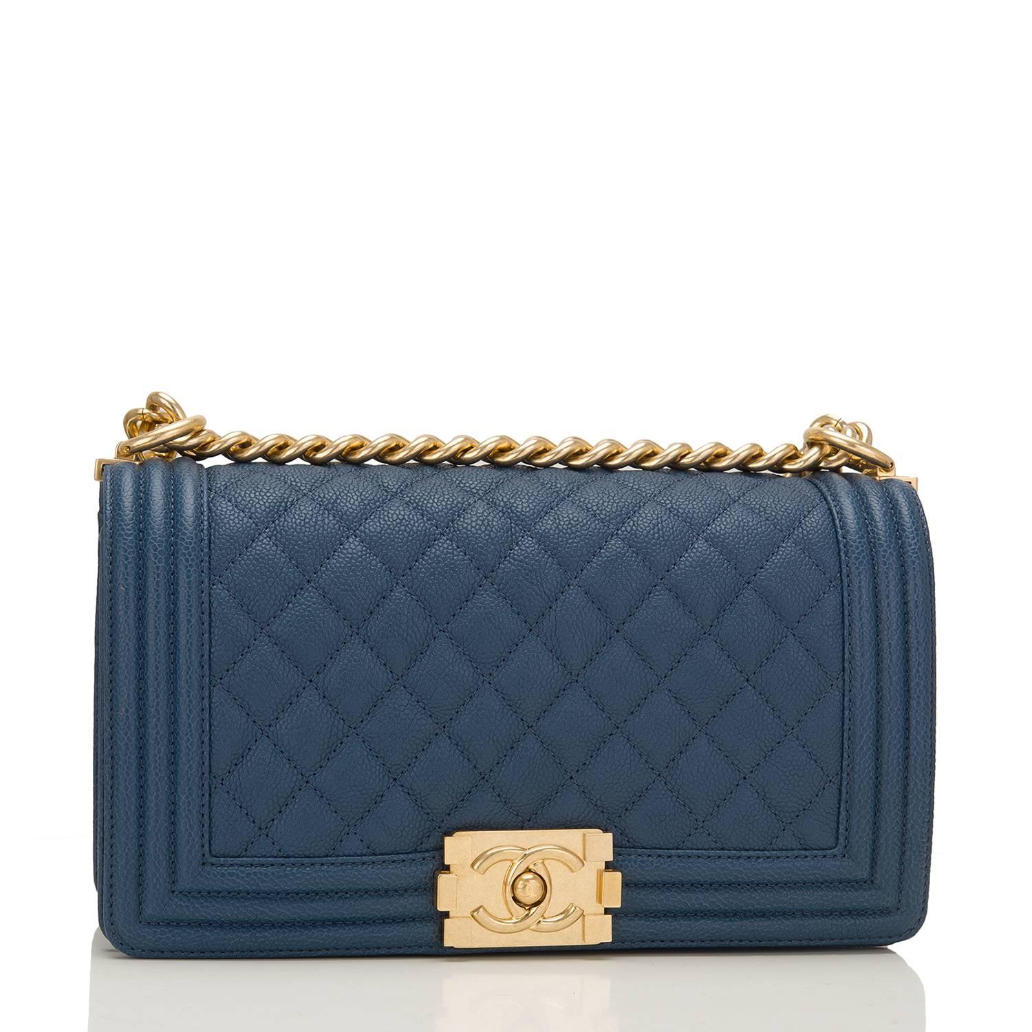 Chanel Old Medium Boy bag of dark blue quilted caviar leather and antique gold hardware.

This Chanel bag is in the classic Boy style with a full front flap with the Boy signature CC push lock closure, smooth leather trim and antique gold chain