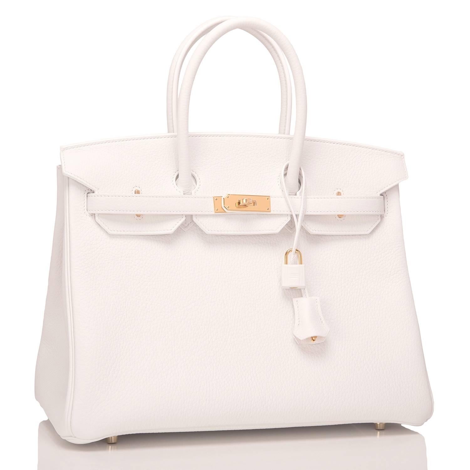 Hermes white Birkin 35cm of taurillon clemence leather with gold hardware.

This white Birkin features tonal stitching, a front toggle closure, a clochette with lock and two keys, and double rolled handles.

The interior is lined with white