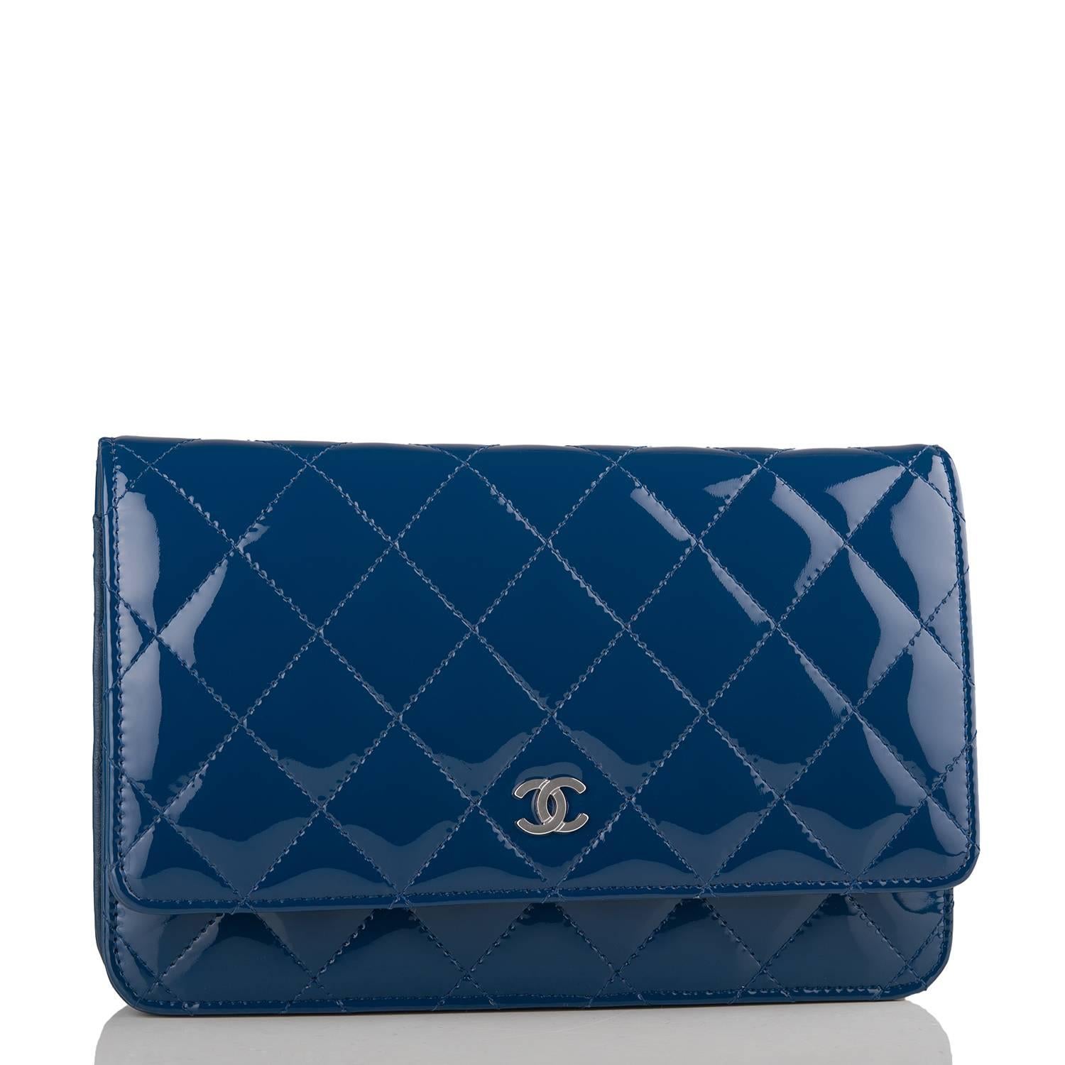 Chanel Classic Wallet On Chain (WOC) of dark blue patent leather with silver tone hardware.

This Wallet On Chain features signature Chanel quilting, a front flap with CC charm and hidden snap closure, a half moon rear pocket, and an interwoven