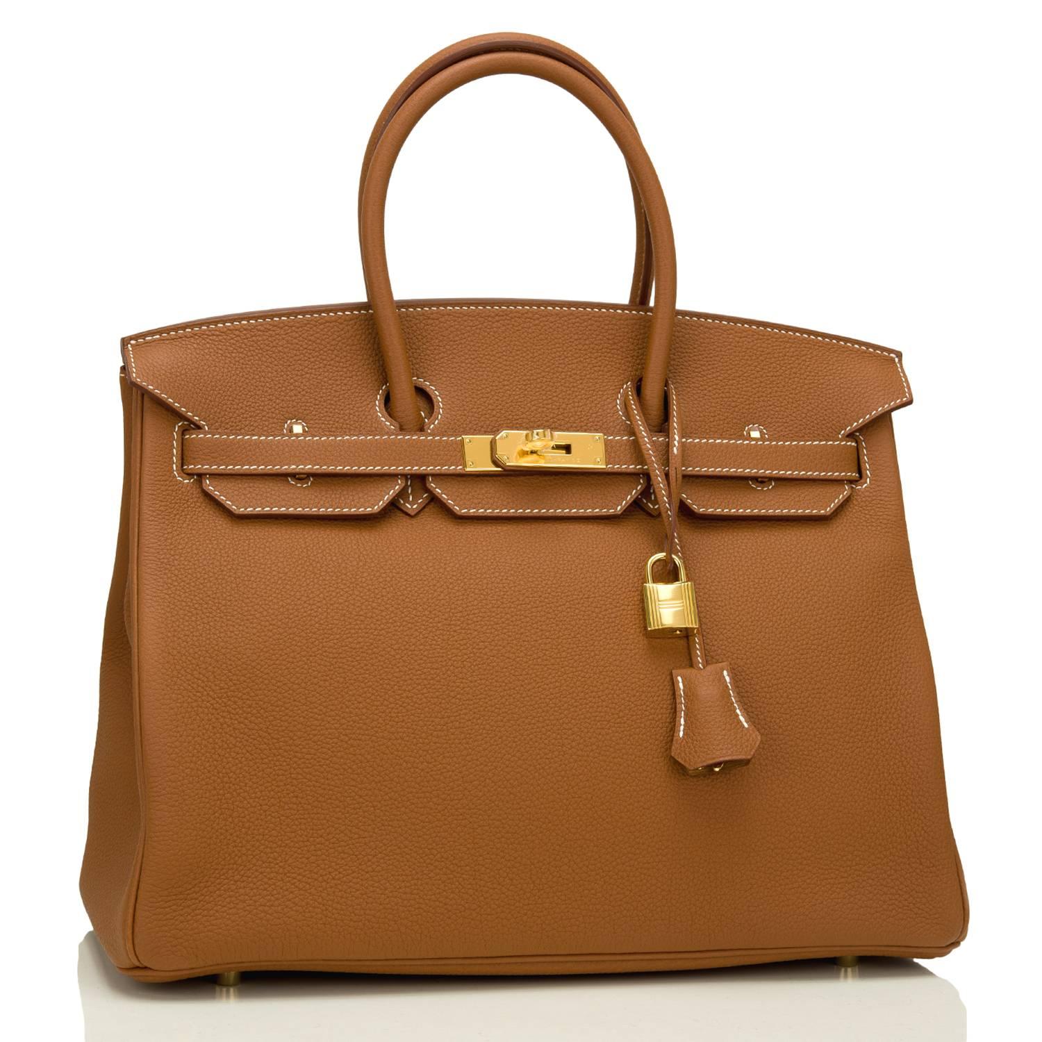 Hermes Gold Birkin 35cm in togo leather with gold hardware. 

This Birkin features white contrast stitching, a front toggle closure, a clochette with lock and two keys, and double rolled handles.

The interior is lined with Gold chevre and has