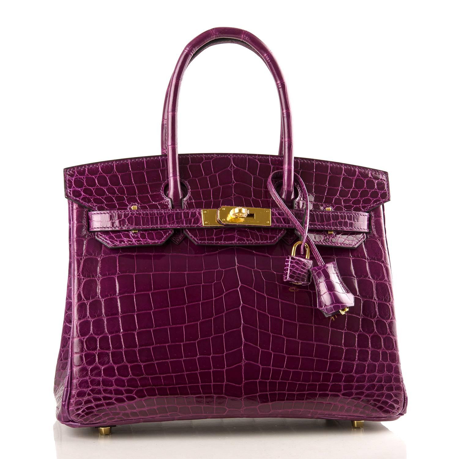 Hermes Cassis Birkin 30cm of shiny niloticus crocodile with gold hardware.

This Birkin has tonal stitching, a front toggle closure, a clochette with lock and two keys, and double rolled handles.

The interior is lined with Cassis chevre and has