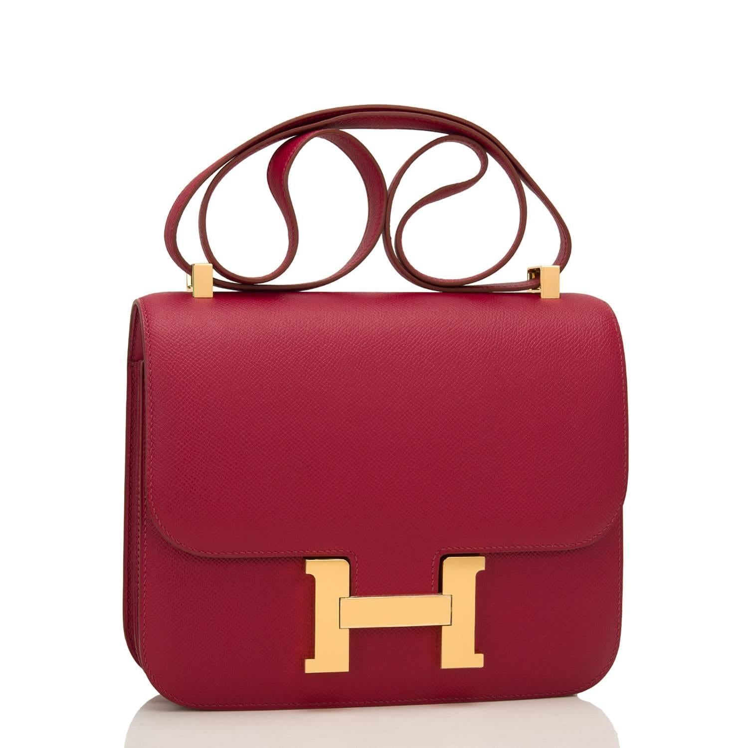 Hermes Rubis Constance 24cm of epsom leather with gold hardware.

This Constance has tonal stitching, a metal "H" snap lock closure, and an adjustable shoulder strap.

The interior is lined with rubis lambskin leather and has a zip pocket