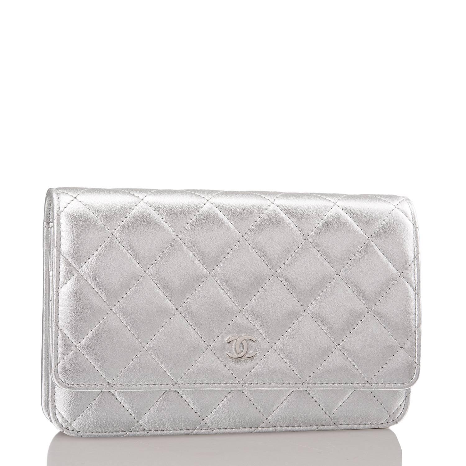 Chanel Classic Wallet On Chain (WOC) of silver lambskin leather with silver tone hardware.

This Wallet On Chain features signature Chanel quilting, a front flap with CC charm and hidden snap closure, a half moon pocket at the rear and an