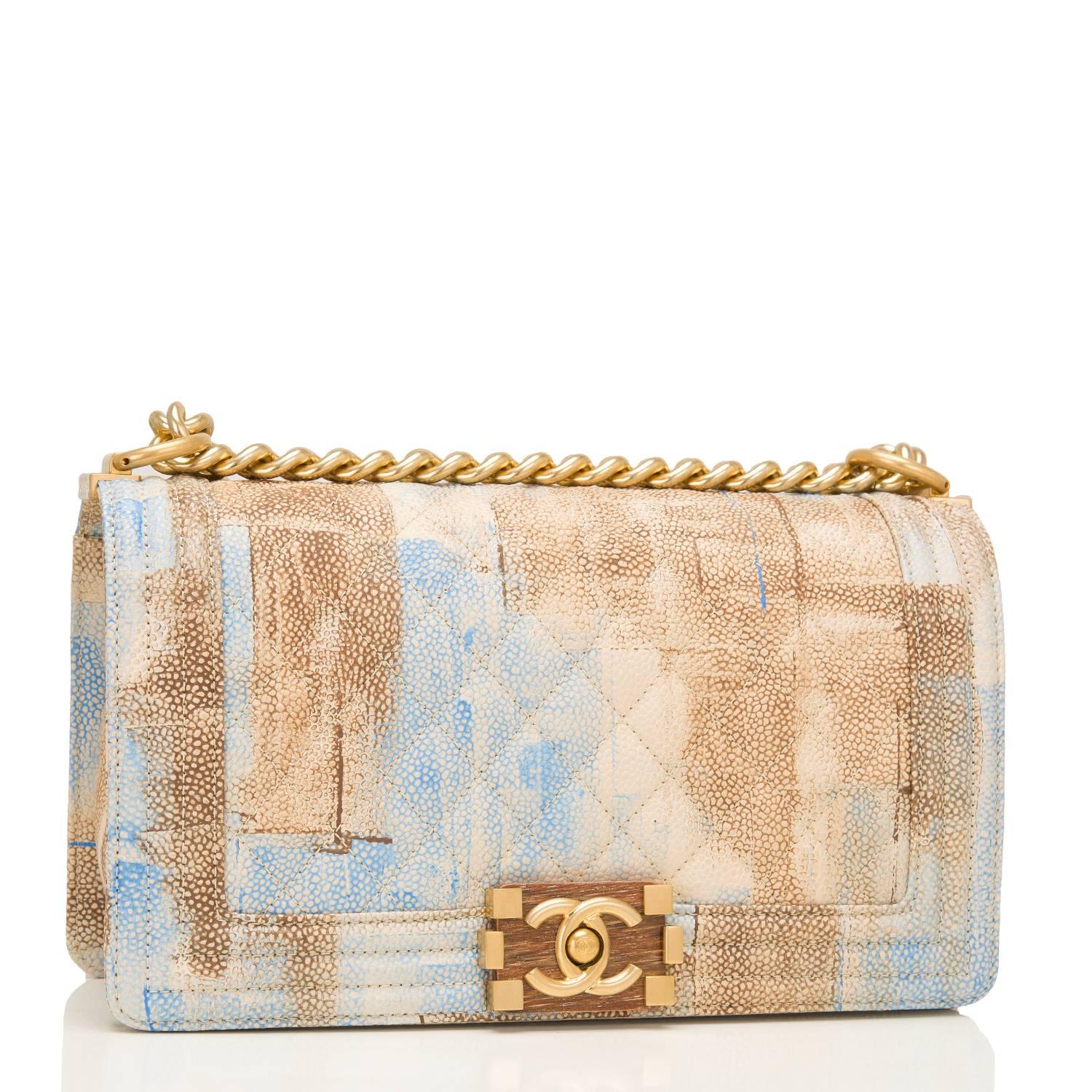 Chanel Old Medium Boy bag of a watercolor printed montage of light brown, cream and blue in caviar leather with antique gold tone hardware.

This Chanel bag from the Cuba collection is in the classic Boy style and features a full front flap with