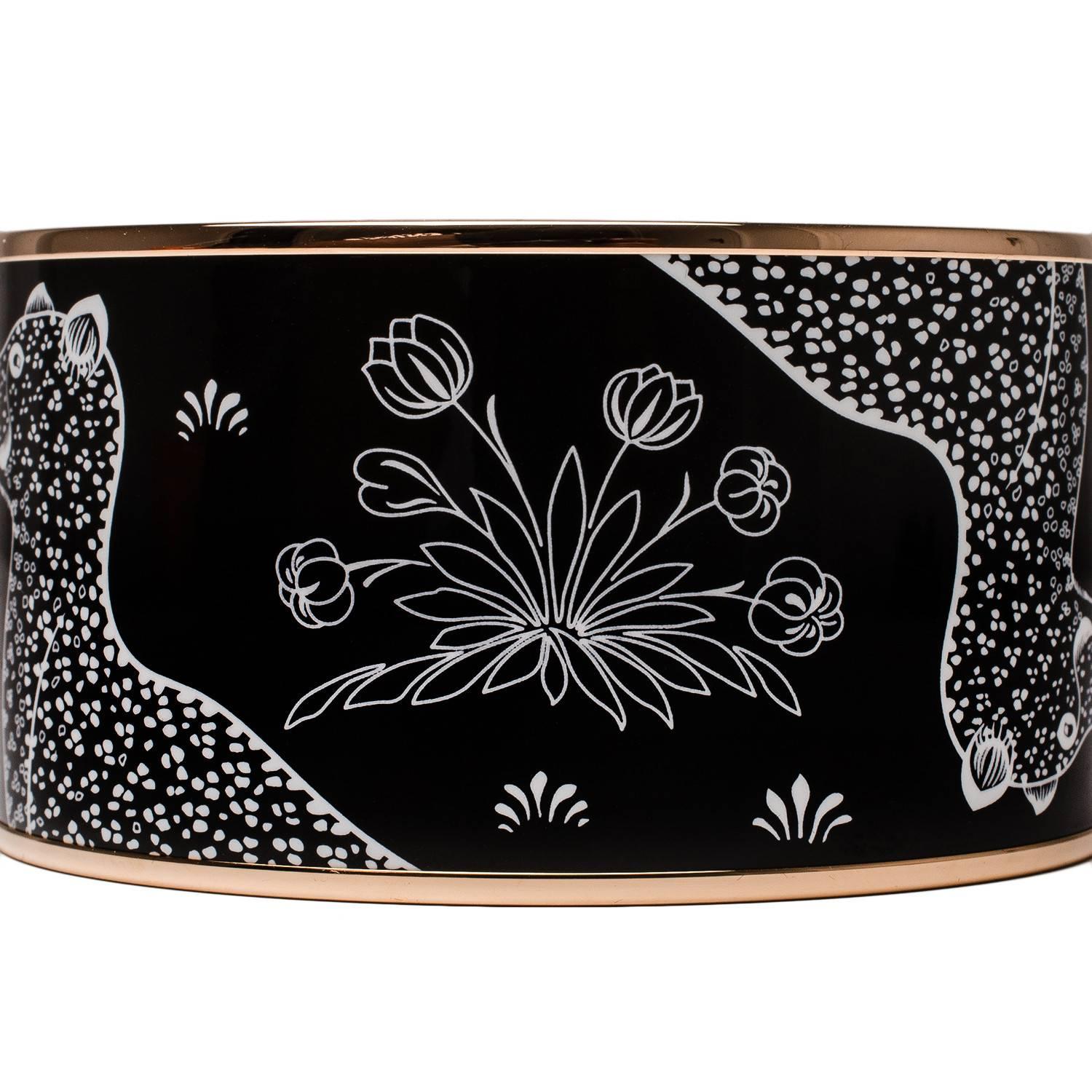 Hermes "Les Leopards" wide printed enamel bracelet size GM (70).
  
This bracelet depicts leopards and flowers in a black background with rose gold plated hardware.

Origin: France
 
Condition: Never worn
 
Accompanied by: Hermes box,