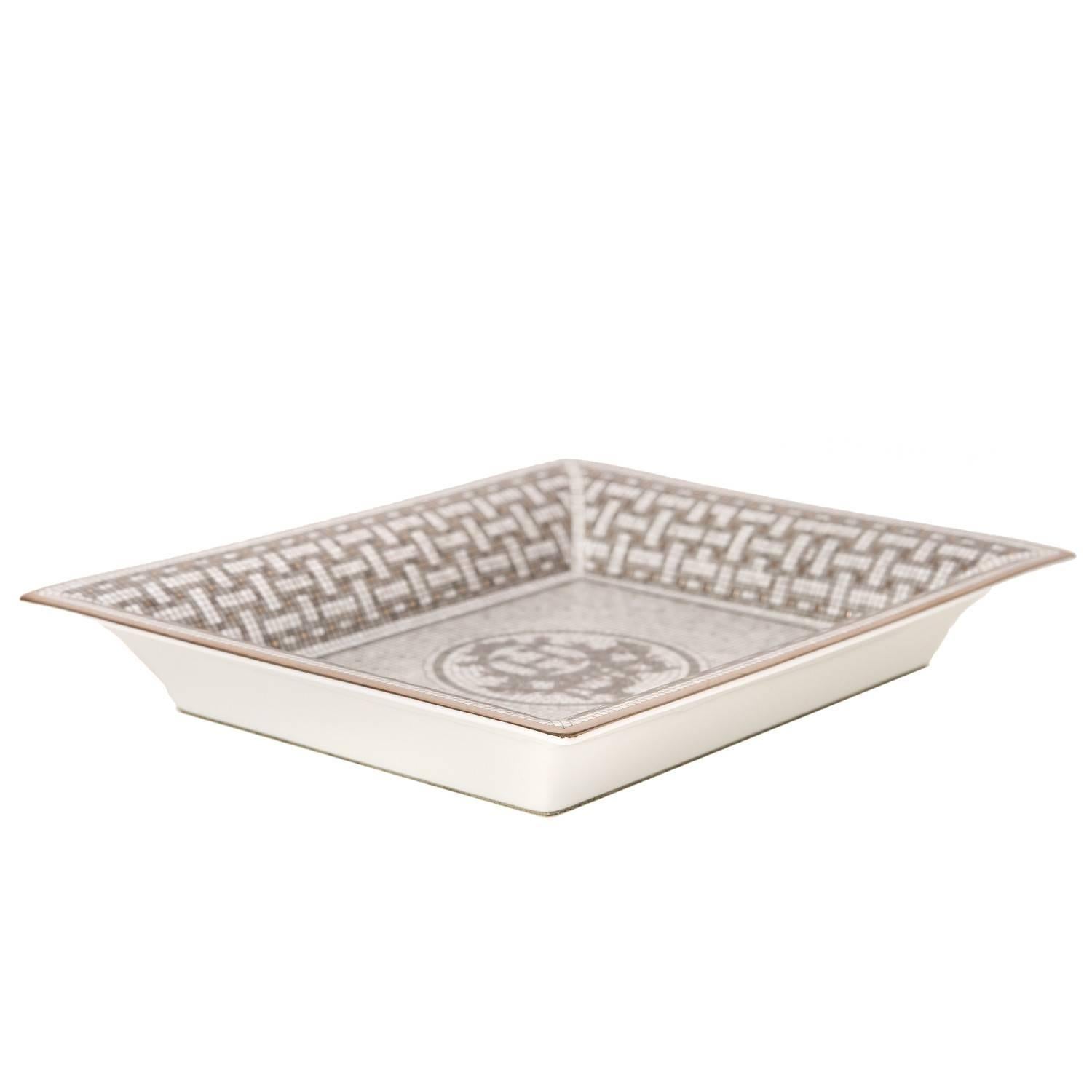Hermes Mosaique au 24 Tray of porcelain in platinum pattern.

The Hermes Mosaique au 24 Tray is a tribute to the birthplace of Hermes: 24 Faubourg Saint Honore in Paris. Taking you to the heart of the boutique's architecture, where each decoration