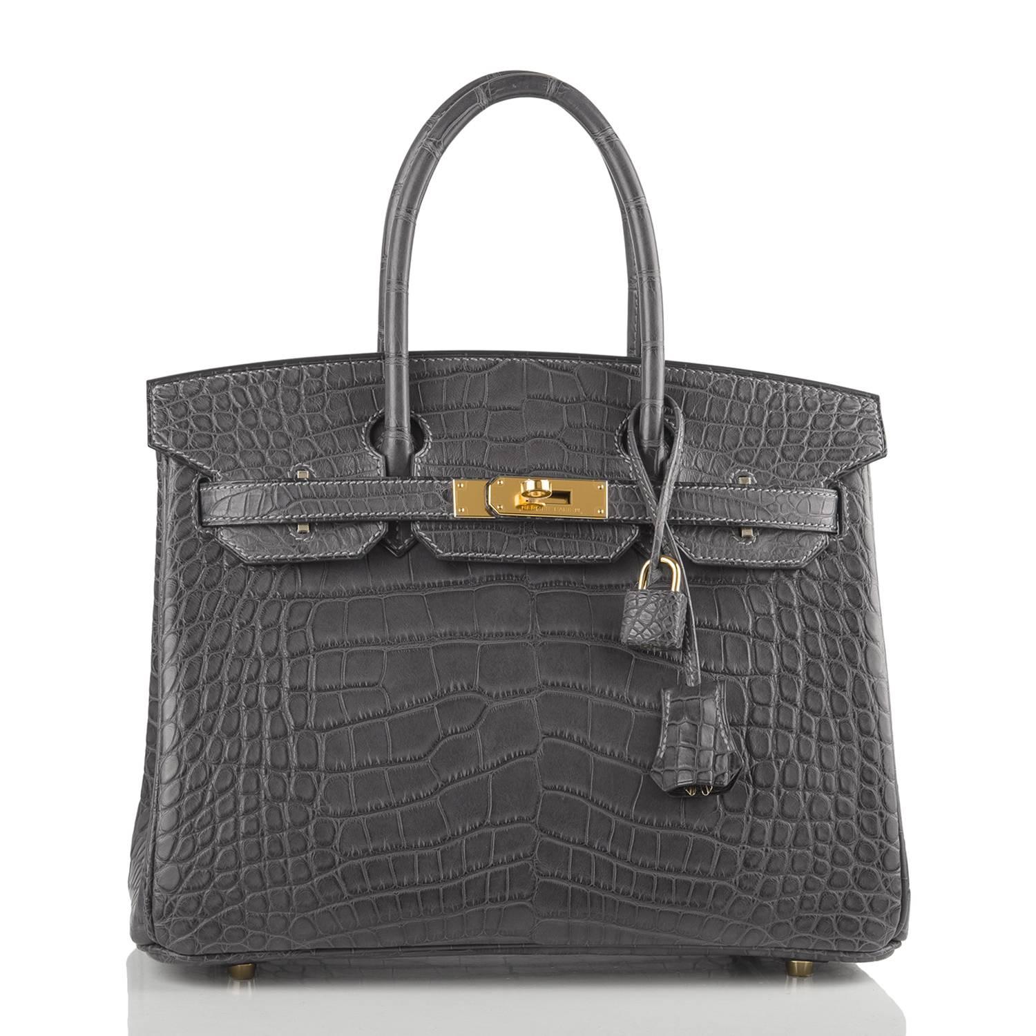 Hermes Graphite Birkin 30cm of matte alligator leather with gold hardware.

This rare Birkin has medium grey stitching, a front toggle closure, a clochette with lock and two keys, and double rolled handles.

The interior is lined with Graphite