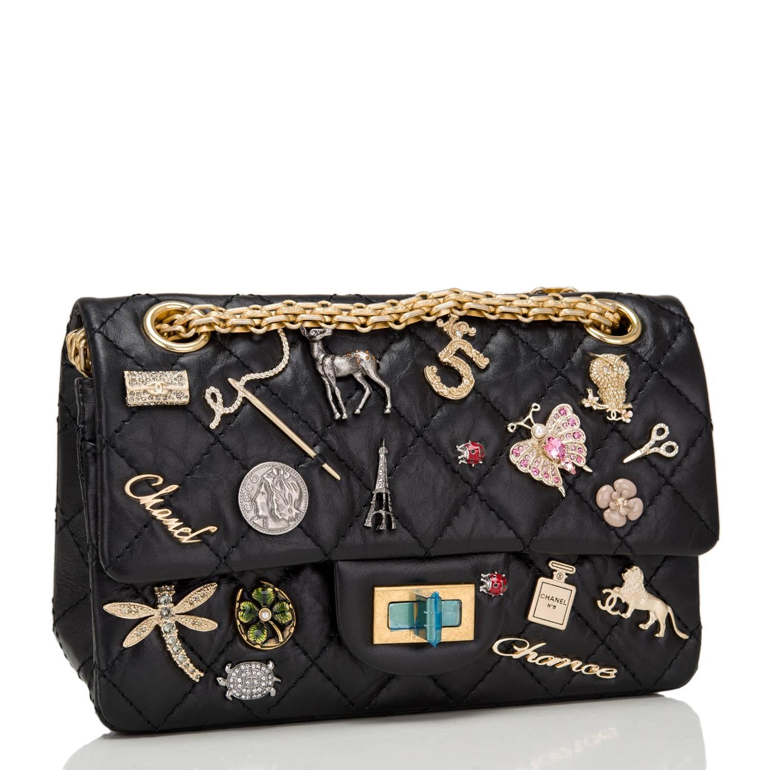 Chanel Lucky Charm Reissue 2.55 bag in black aged calfskin leather with gold tone hardware in size 224.

This embellished bag features 19 iconic Chanel charms, front flap with Mademoiselle turnlock closure, a half moon back pocket, and adjustable