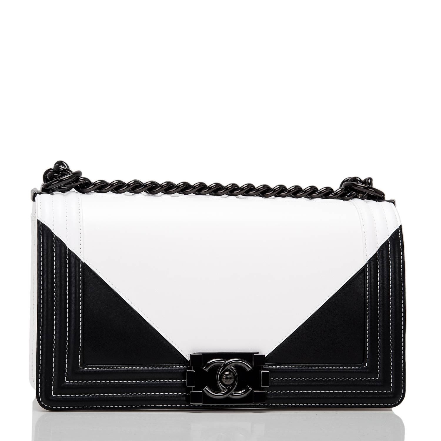 Chanel Old Medium Boy bag of black and white lambskin leather and black hardware.

This Chanel bag is in the Boy style with a full front flap with the Boy signature CC push lock closure, white stitching, smooth leather trim and black metal chain