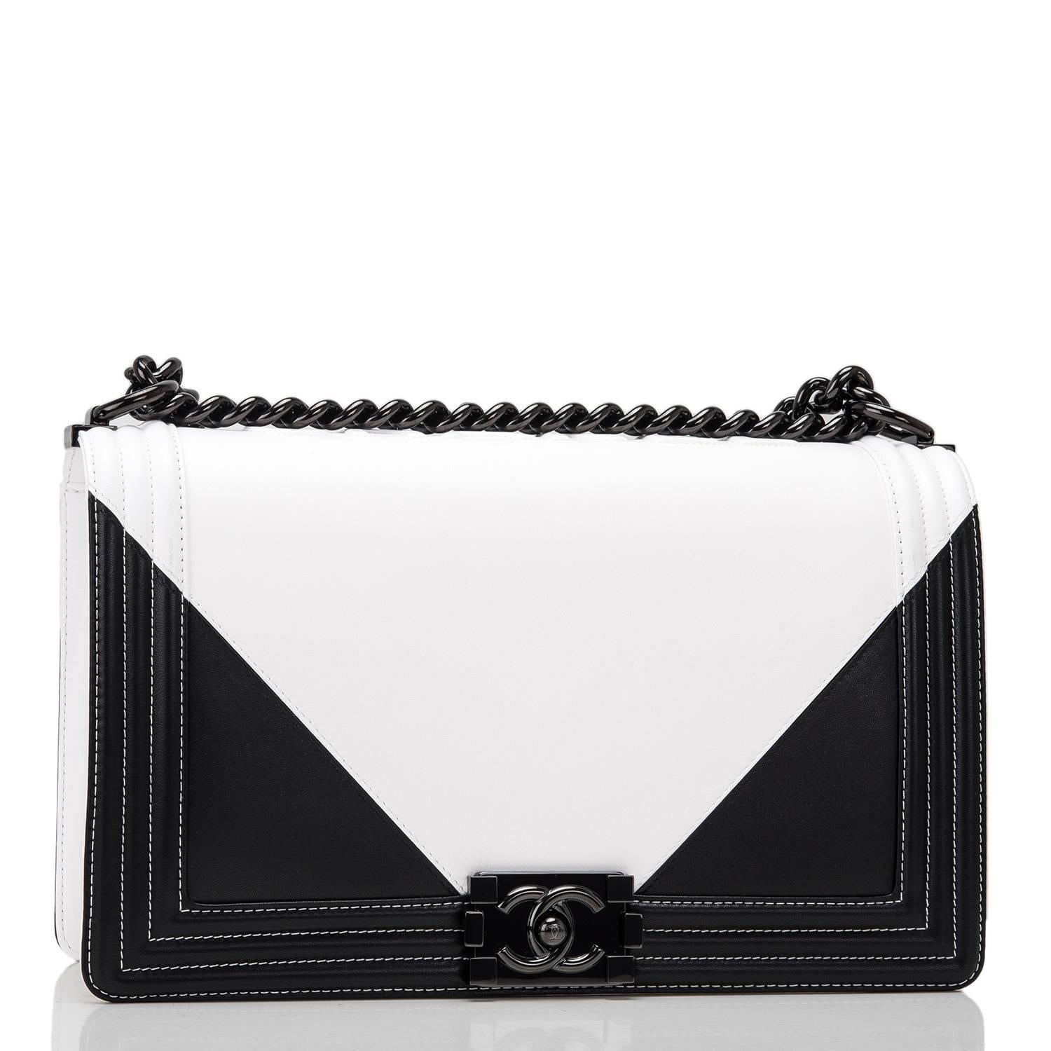 Chanel New Medium Boy bag of black and white lambskin leather and black hardware.

This Chanel bag is in the Boy style with a full front flap with the Boy signature CC push lock closure, white stitching, smooth leather trim and black metal chain