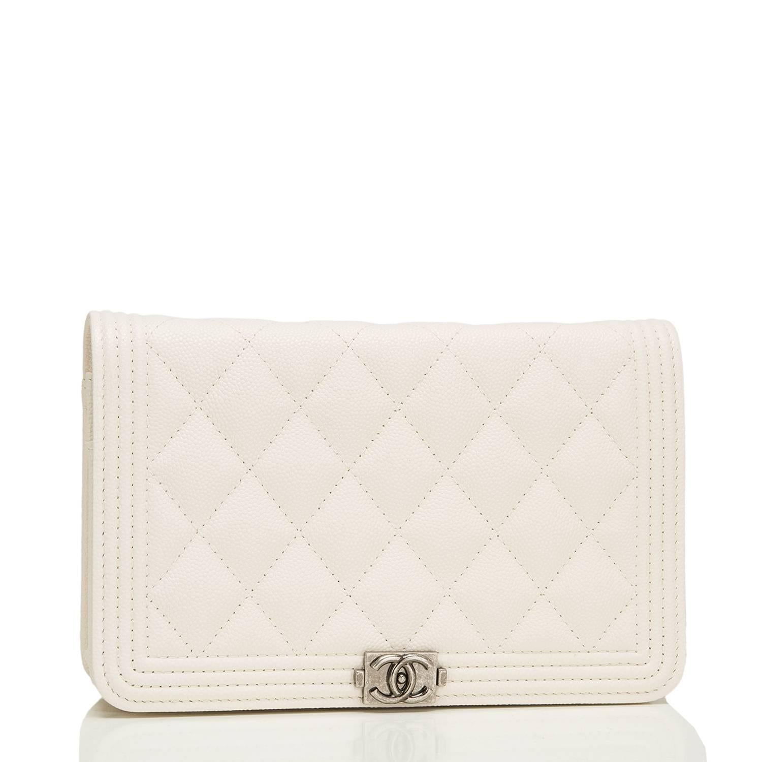 Chanel quilted Boy Wallet on Chain (WOC) of ivory caviar leather with ruthenium hardware.

This Wallet On Chain features a front flap with the signature Le Boy CC charm and hidden snap closure and a ruthenium metal chain link with ivory leather