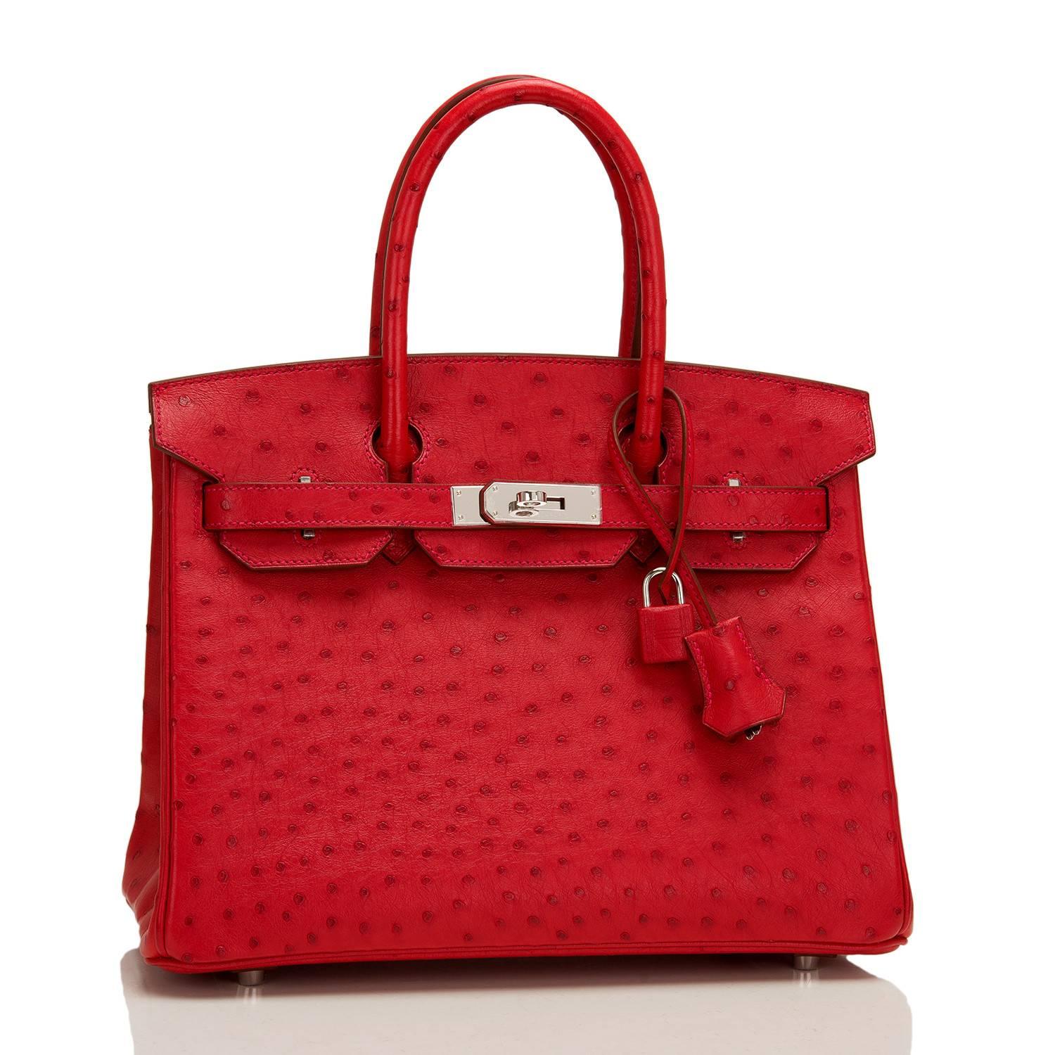 Hermes Rouge Vif Birkin 30cm of Ostrich with palladium hardware.

This Birkin has tonal stitching, a front toggle closure, a clochette with lock and two keys, and double rolled handles.

The interior is lined with Rouge Vif chevre and has a zip