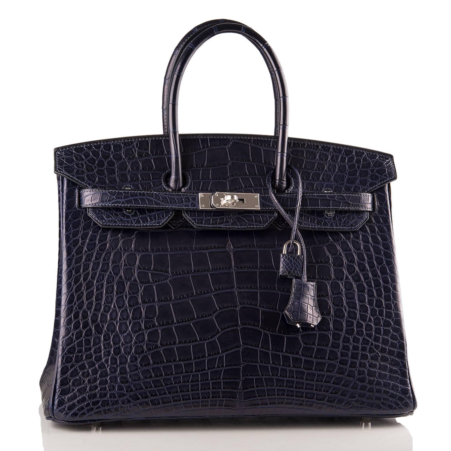 Hermes Blue Marine Birkin 35cm of matte alligator leather with palladium hardware.

This Birkin has tonal stitching, a front toggle closure, a clochette with lock and two keys, and double rolled handles.

The interior is lined with Blue Marine