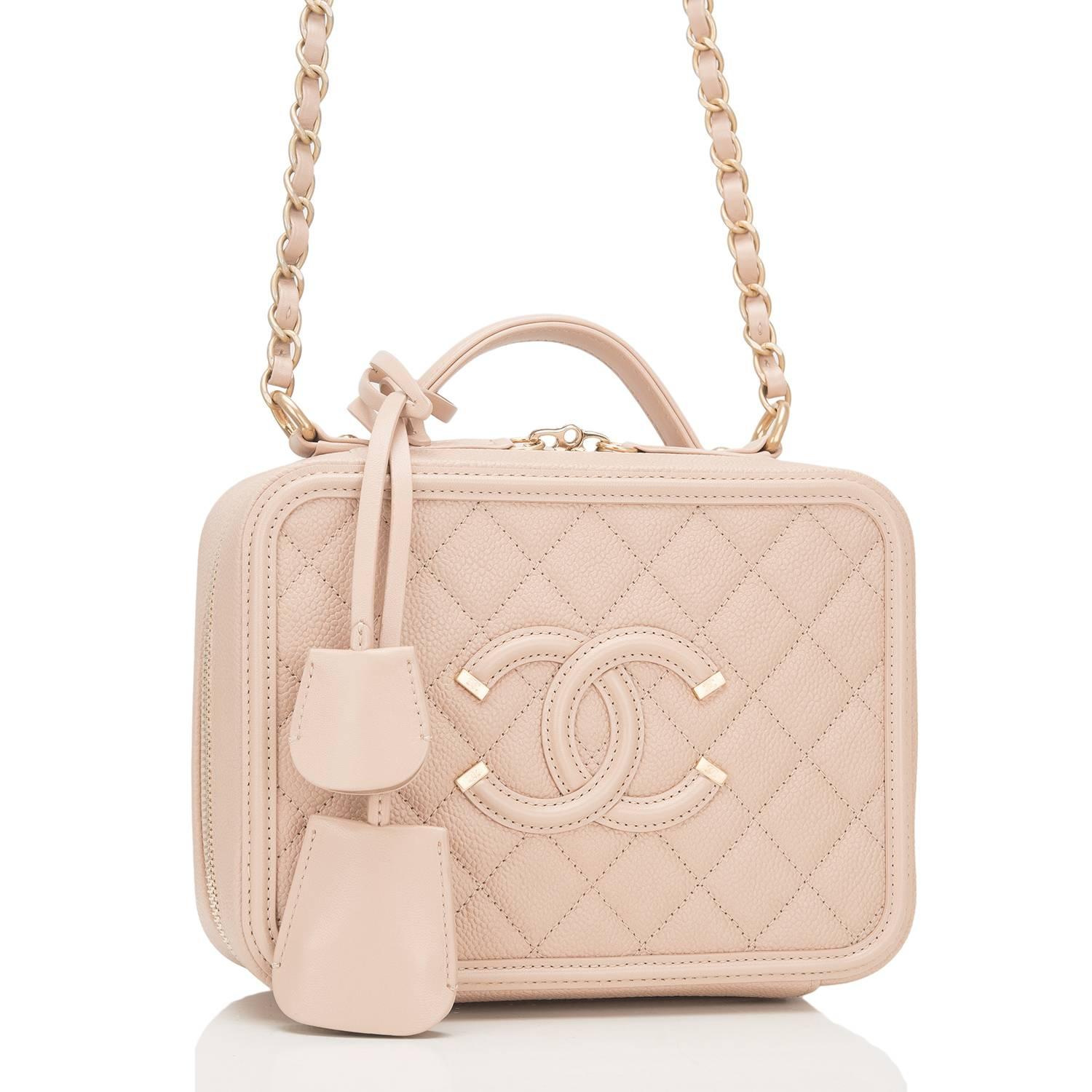 Chanel Small Filigree Vanity Case of light beige caviar leather with gold tone hardware.

This bag features Chanel's signature CC logo stitch in on the front, a gold tone CC lock with a clochette, a matching key with another clochette, zip around