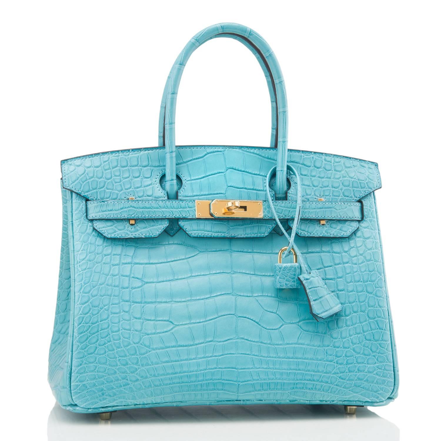 Hermes Blue Saint Cyr Birkin 30cm of matte alligator with gold hardware.

This Birkin has tonal stitching, a front toggle closure, a clochette with lock and two keys, and double rolled handles.

The interior is lined with Blue Saint Cyr chevre and