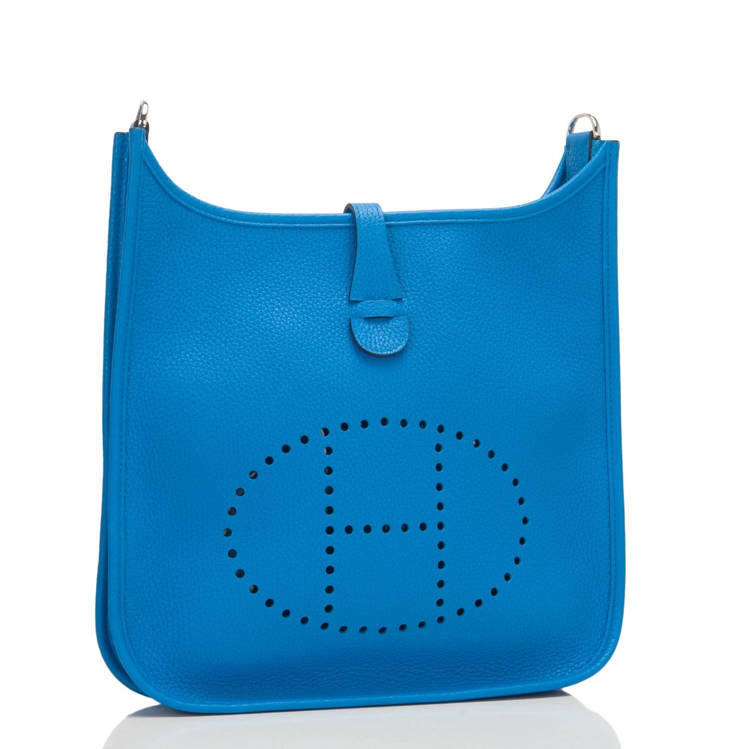 Hermes Evelyne PM of Blue Zanzibar clemence leather with palladium hardware.

This Evelyne has tonal stitching, a large perforated H icon in circle at front, a rear pocket, a pull tab top closure that has a snap closure at the rear, and a Blue