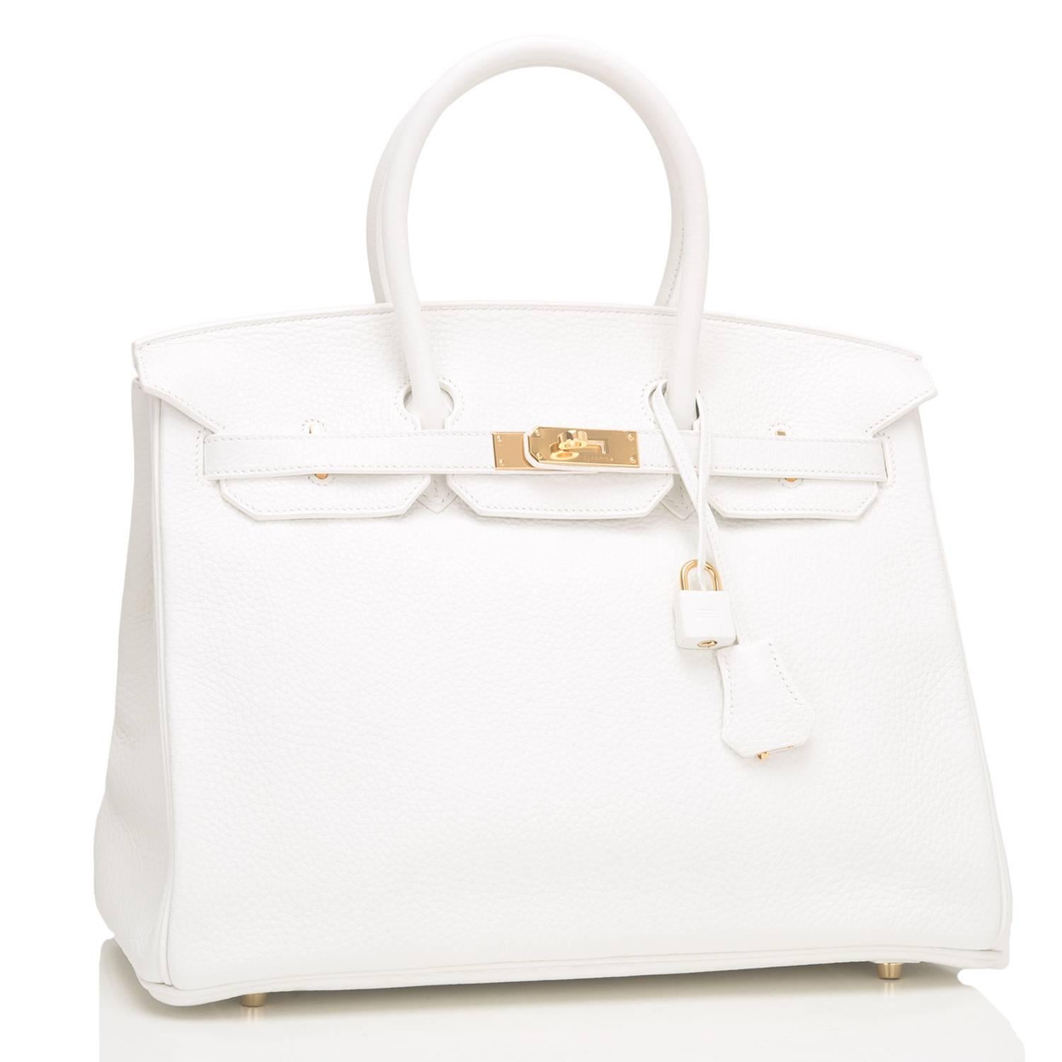 Hermes white Birkin 35cm of taurillon clemence leather with gold hardware.

This white Birkin features tonal stitching, a front toggle closure, a clochette with lock and two keys, and double rolled handles.

The interior is lined with white chevre