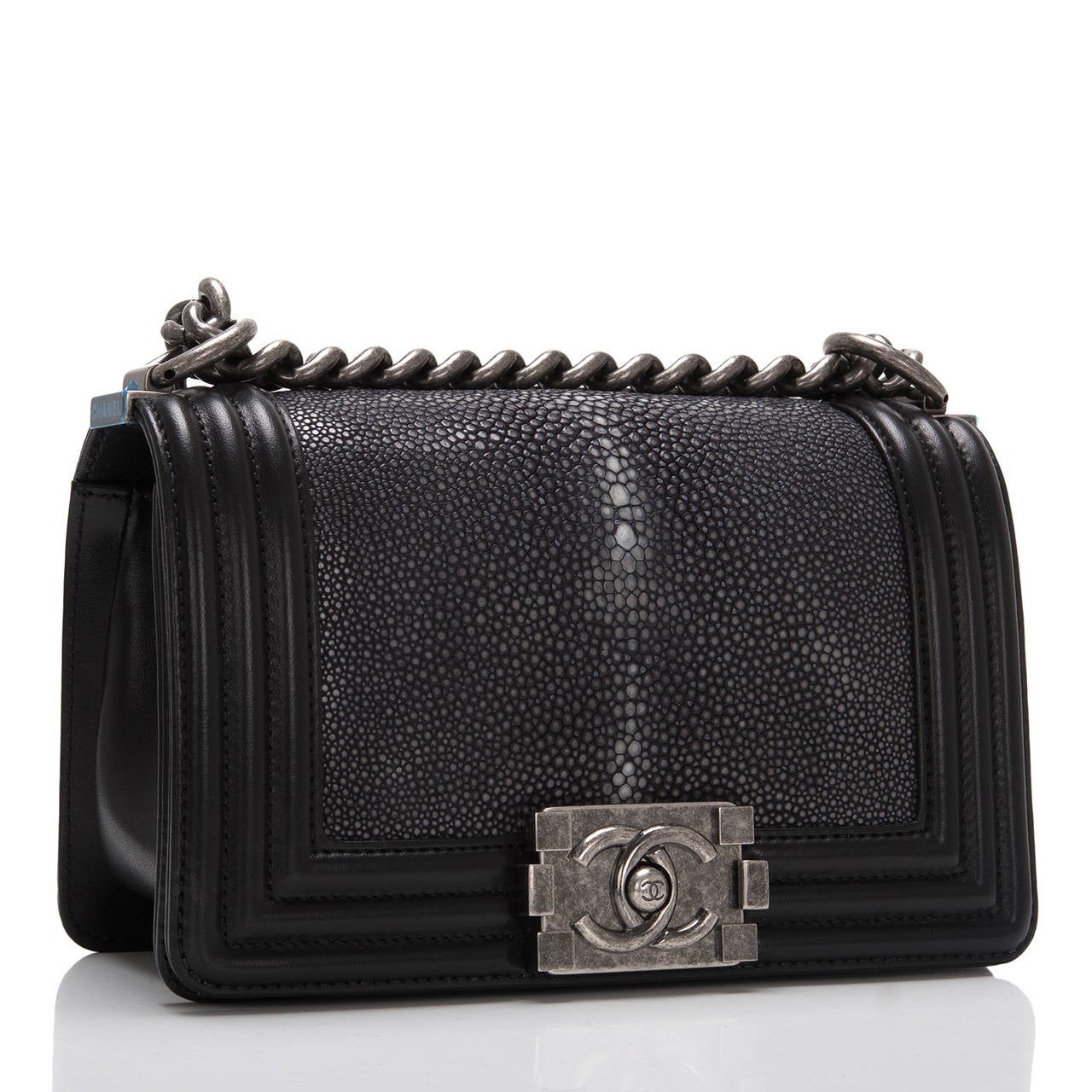 This limited edition Small Boy bag is exceptional in black stingray, accented by black lambskin leather and aged ruthenium hardware. The bag has a full front flap with the Boy Chanel signature CC push lock closure and aged ruthenium chain link and