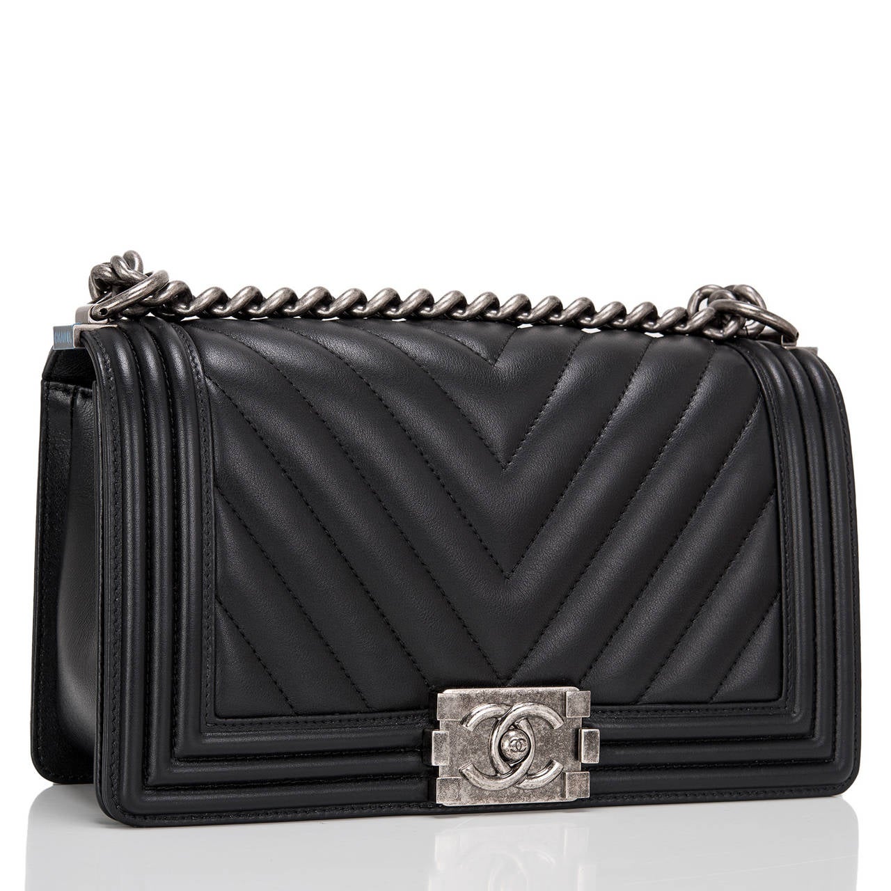 This Chanel black Chevron Medium Boy bag features beautiful black quilted chevron calfskin and aged ruthenium hardware. This Chanel bag is in the classic Boy style with a full front flap with the Boy signature CC push lock closure detail and aged