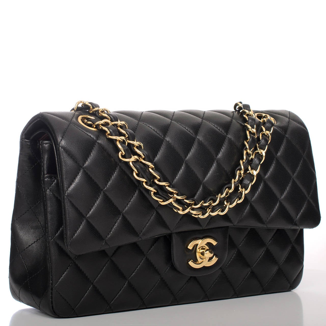 This Chanel Large Classic double flap marries smooth black lambskin with gold tone hardware. The bag features a front flap with signature CC turnlock closure, half moon back pocket and an adjustable interwoven gold tone chain link and black leather