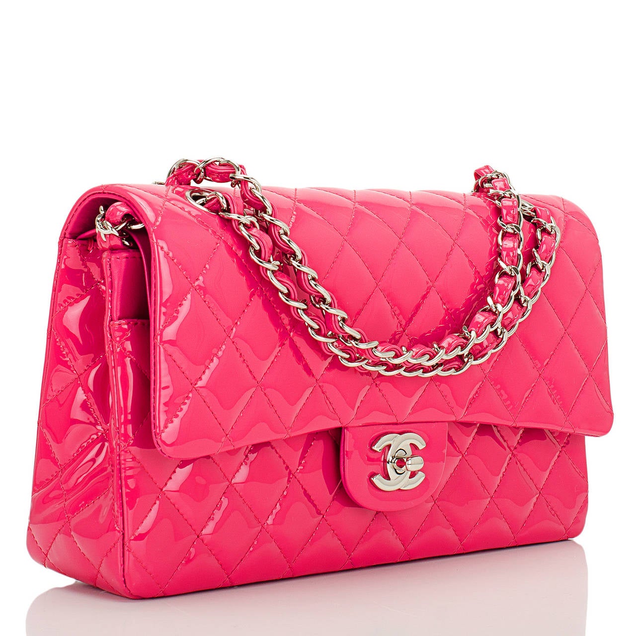 Chanel Medium Classic double flap bag of fuchsia pink patent leather with silver tone hardware.

This bag features a front flap with signature CC turnlock closure, a half moon back pocket, and an adjustable interwoven silver tone chain link with