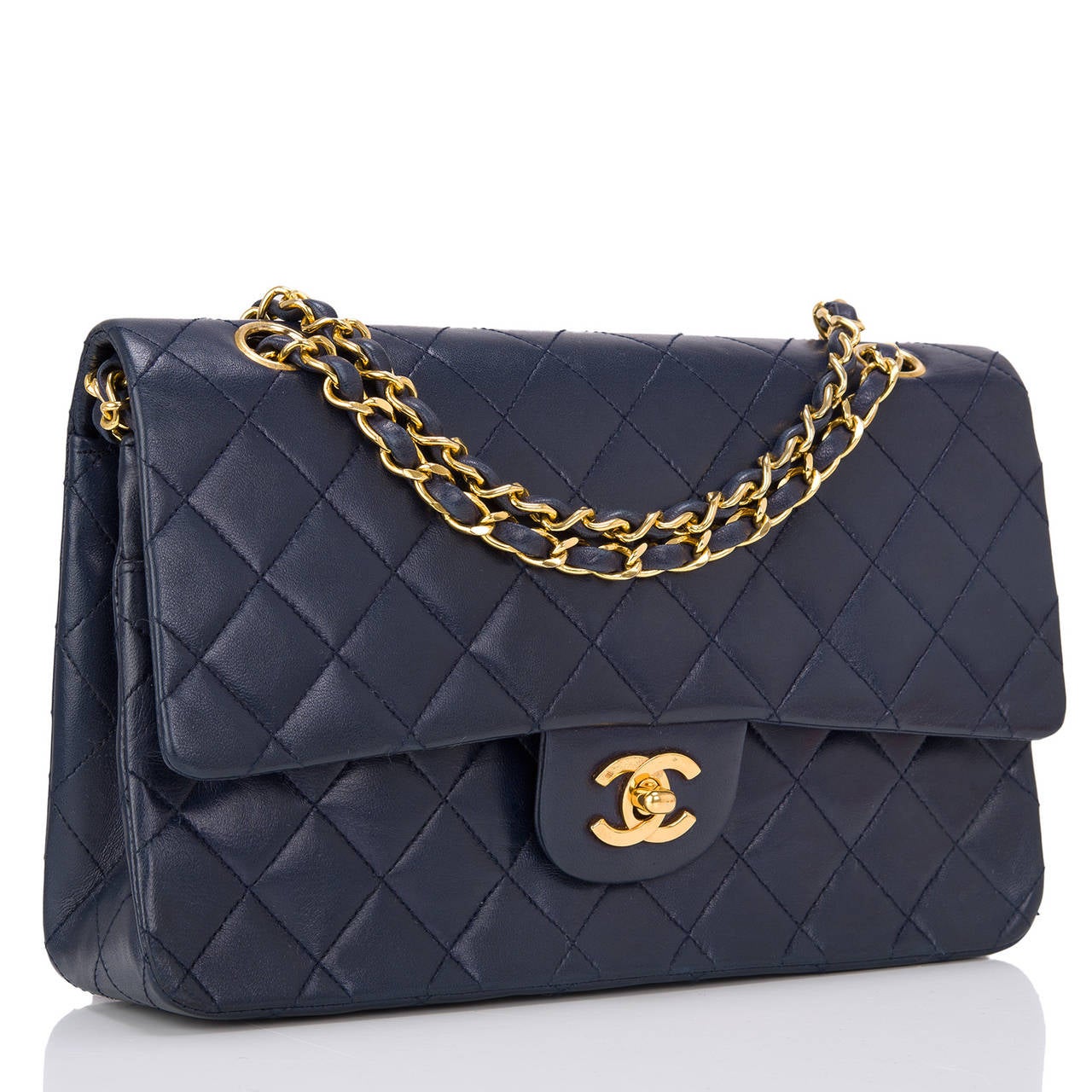 This rare and beautiful vintage Chanel Navy Large Classic double flap bag made of quilted lambskin leather with gold tone hardware. As with all Chanel classic bags, this stunning bag features a front flap with signature CC turnlock closure, half
