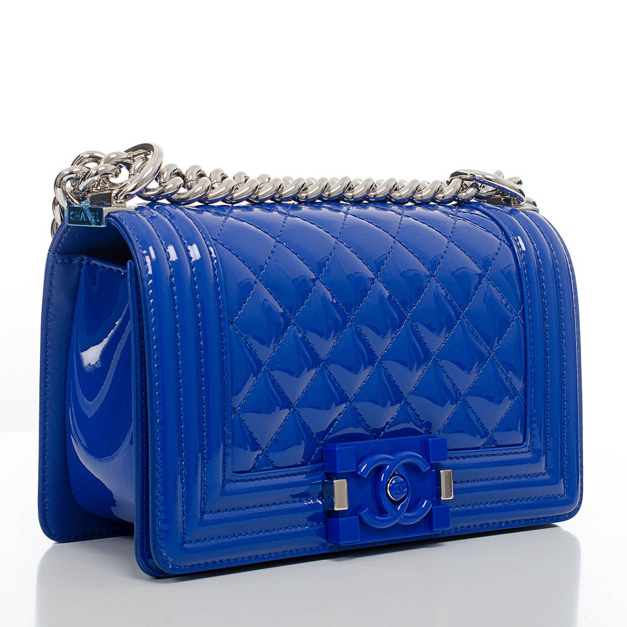 This limited edition Small Boy style features blue marine quilted patent lather and silver tone hardware. This bag features a front flap with a blue marine plexiglass CC push lock closure and a silver tone chain link and blue marine leather padded