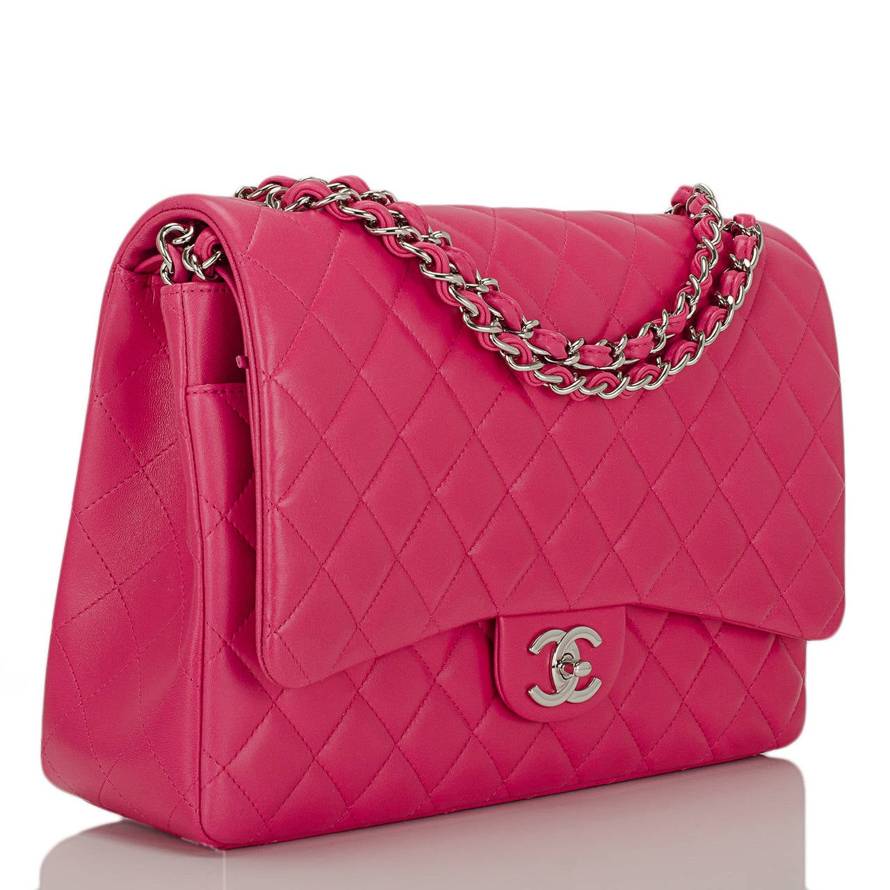 Chanel Maxi Classic double flap in a limited edition fuchsia pink quilted lambskin leather with silver tone hardware and featuring a front flap with signature CC turnlock closure, a half moon back pocket, and an adjustable interwoven silver tone