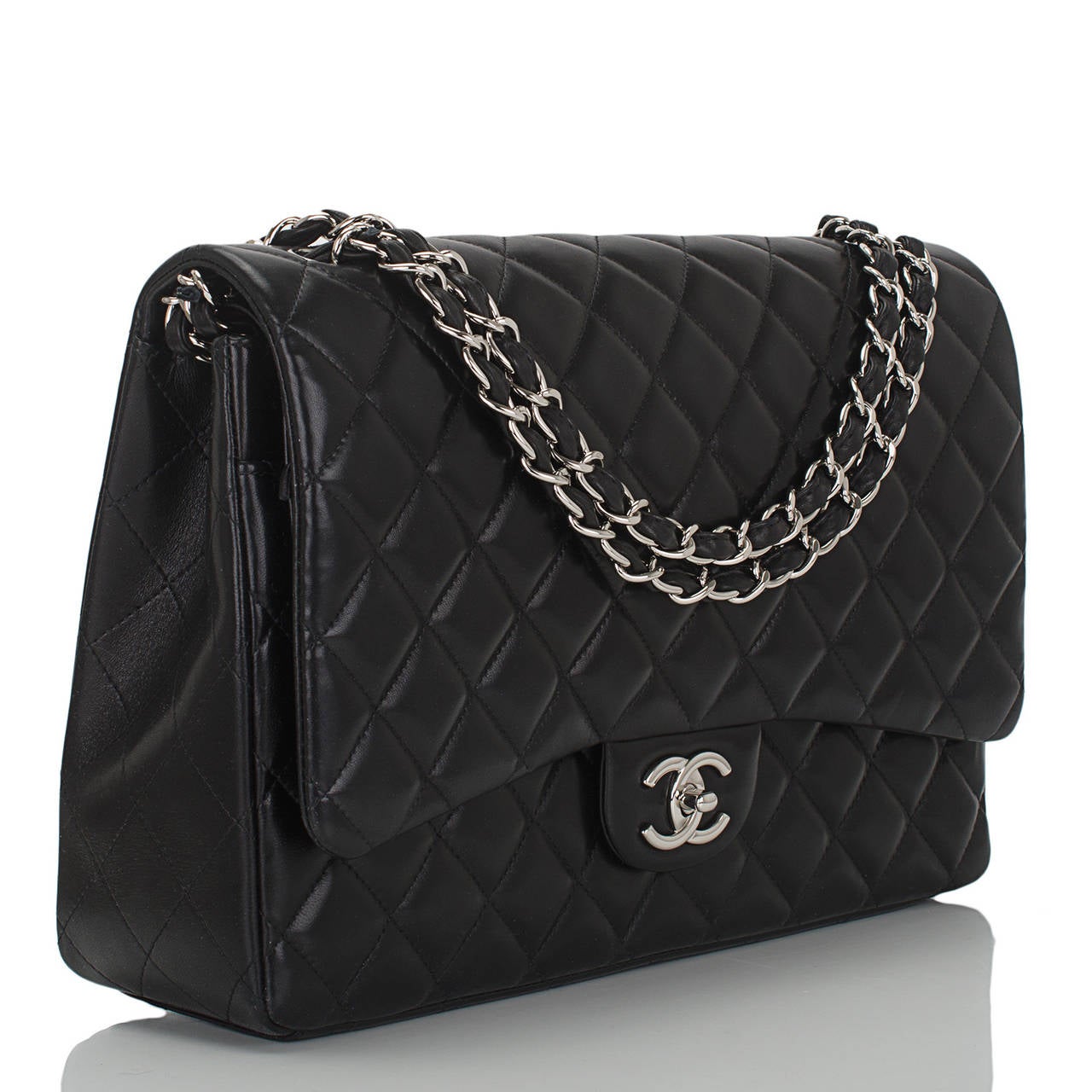 This Chanel Maxi Classic double flap of black quilted lambskin leather features a front flap with signature CC turnlock closure, a half moon back pocket, and an adjustable interwoven silver tone chain link and black leather shoulder strap.

The