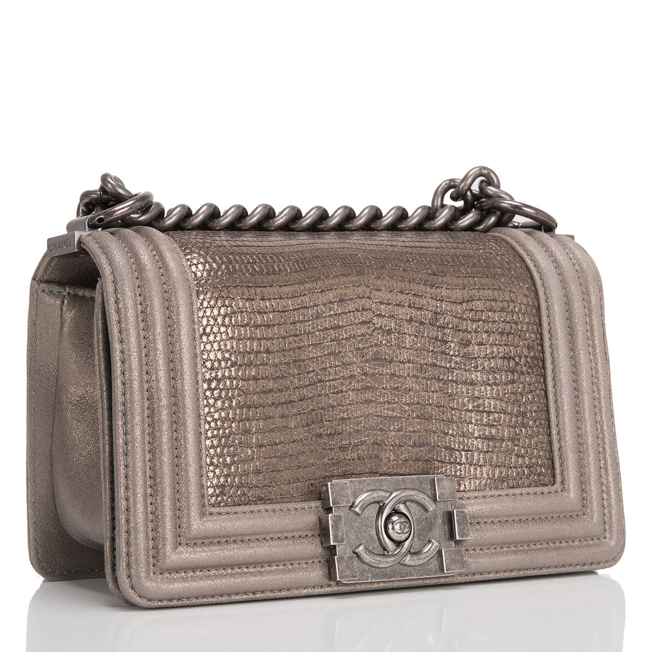 This limited edition Small Boy bag is exceptional in bronze lizard, accented by metallic bronzed lambskin leather and aged ruthenium hardware. The bag has a full front flap with the Boy Chanel signature CC push lock closure and aged ruthenium chain