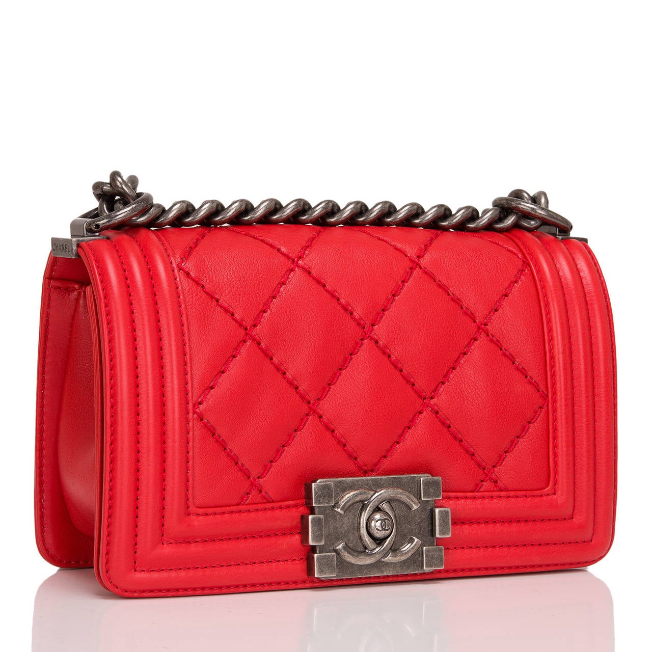 This Chanel Small Double Quilt Boy bag marries beautiful red quilted calfskin with ruthenium hardware. Like all the Boy styles, this bag features a front flap with the Boy Chanel signature CC push lock closure and ruthenium chain link and red