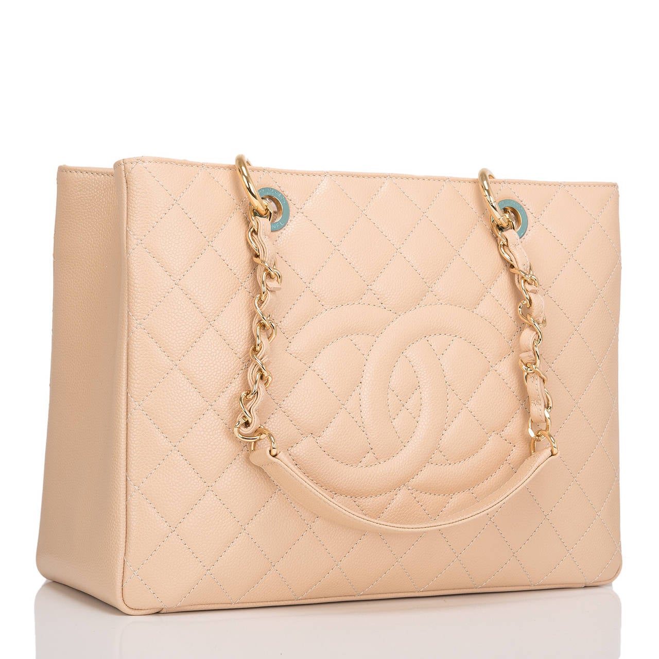 Chanel beige quilted caviar leather Grand Shopper Tote (GST) bag with gold tone hardware.

This style features a front stitched CC logo, half moon back pocket and double interwoven goldtone chain link and leather padded straps.

The interior is