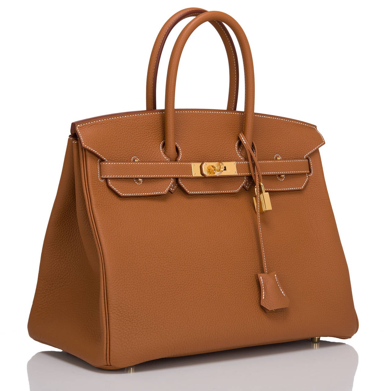 Hermes Gold Birkin 35cm in togo (bull) leather with gold hardware.

This Birkin features white contrast stitching, front toggle closure, clochette with lock and two keys, and double rolled handles.

The interior is lined in Gold chevre with one