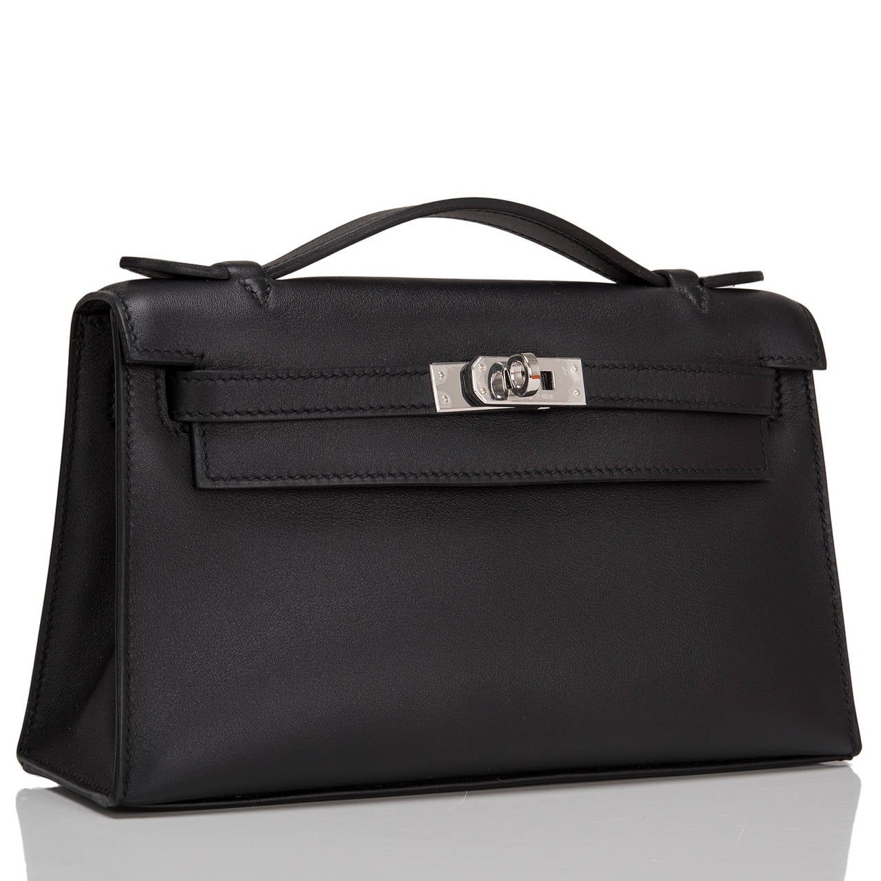 Hermes black swift leather Kelly Pochette clutch with palladium hardware.

This swift leather Kelly Pochette features tonal stitching, a front flap with two straps, toggle closure and single flat handle. The interior is lined in black chevre and