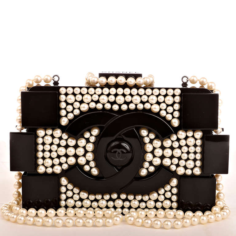 Chanel Pearlized Lego Clutch Boy Bag with faux pearl detail on front and back, large black CC logo with CC center, and faux pearl shoulder/crossbody strap which can be tucked inside and worn as a clutch. Interior is lined in black leather with