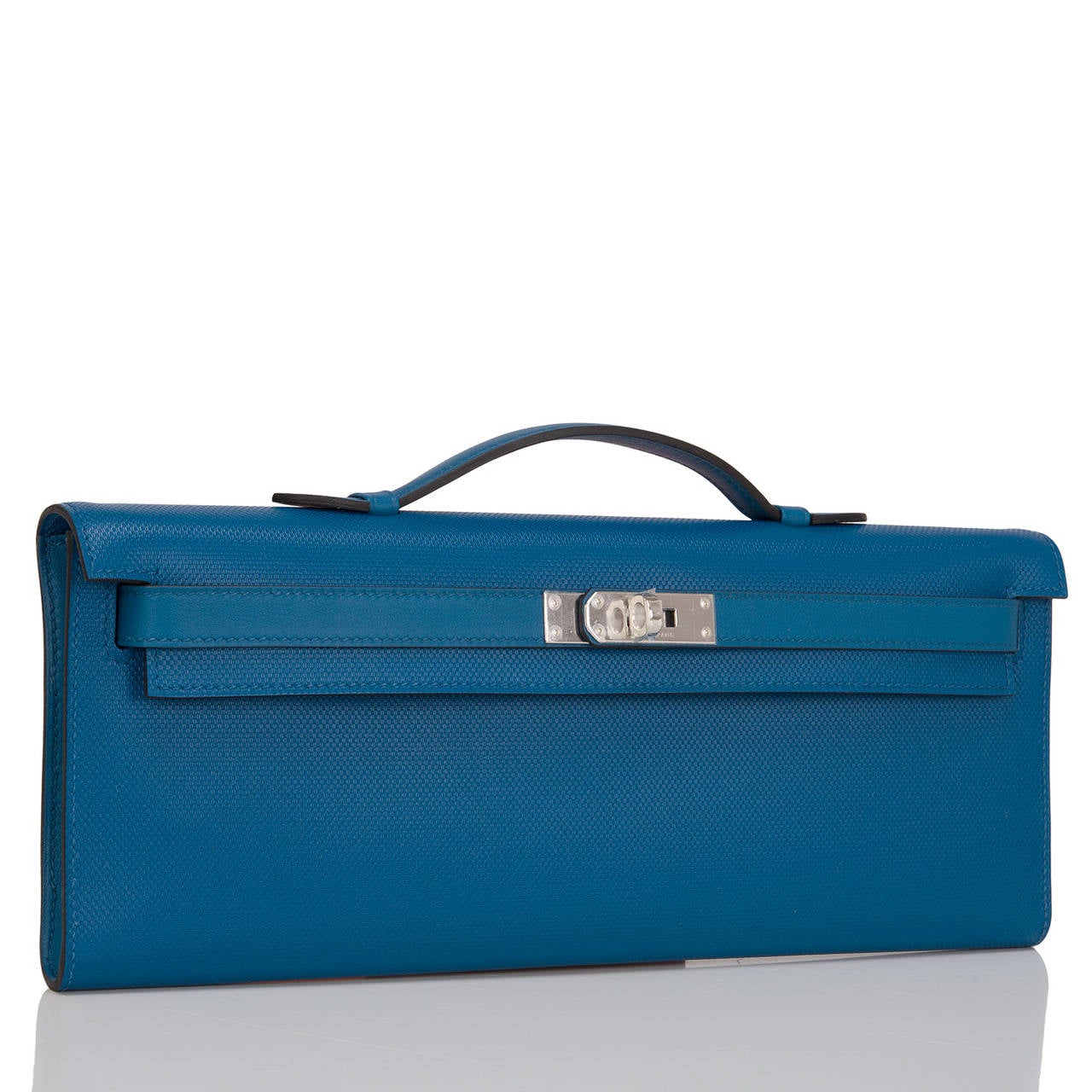This Hermes Kelly Cut in Blue de Galice is gorgeous in Veau Grain d'H leather that is elegant with palladium hardware; the bag has tonal stitching, swift leather front straps with toggle closure and a top flat handle.

The interior is lined in