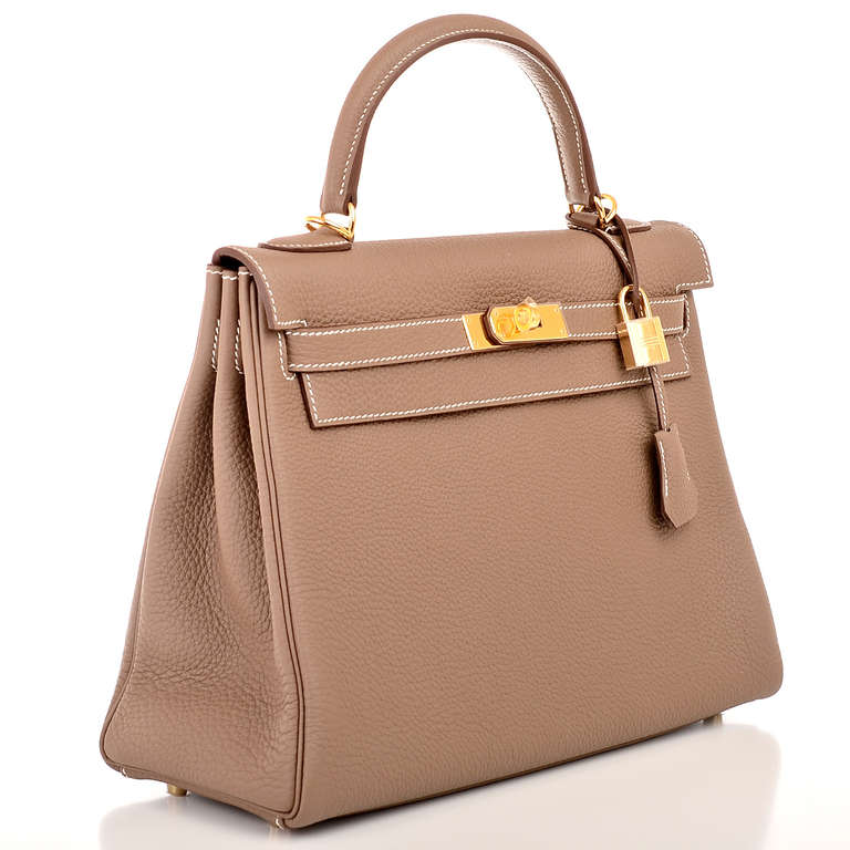 Hermes Etoupe togo leather Kelly 32cm with white contrast stitching, gold hardware, front toggle closure, clochette with lock and two keys, single rolled handle and removable shoulder strap. Interior is lined in Etoupe chevre and features: one zip