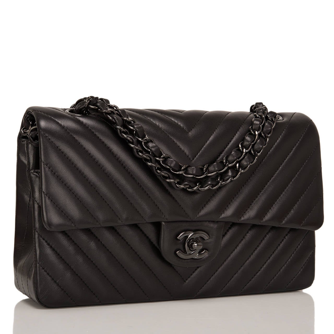 This limited edition Chanel So Black Chevron Large classic double flap bag in black lambskin leather and black metal hardware is an edgy take on the iconic Chanel Classic bag. It features a front flap with signature CC turnlock closure, half moon