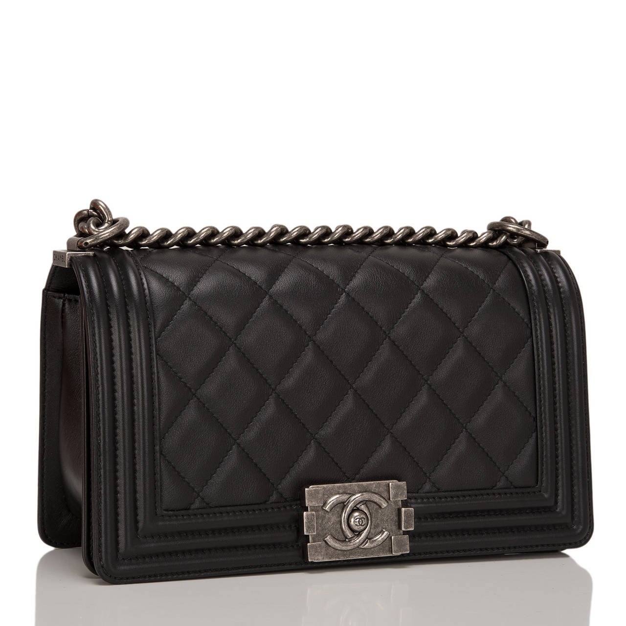 This New Medium Boy bag marries black quilted calfskin leather with aged ruthenium hardware. The bag is of quilted leather trimmed in smooth leather with smooth leather sides and bottom, a full front flap with the Boy Chanel signature CC push lock