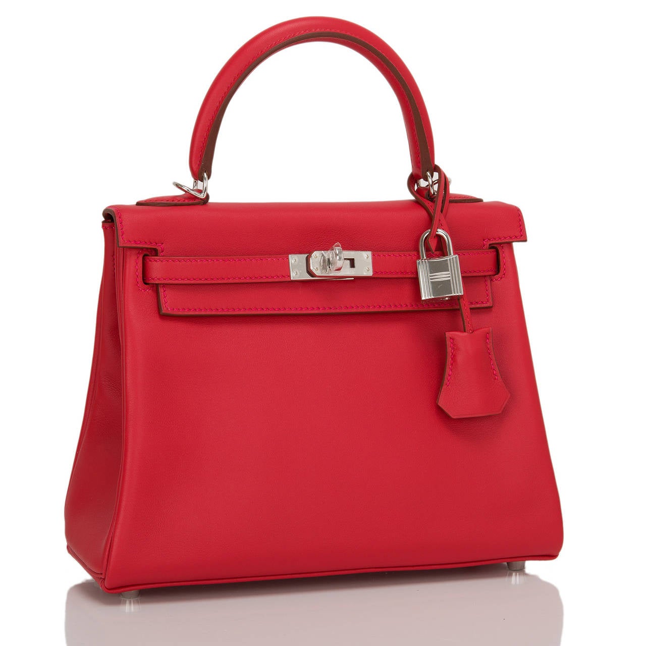 Hermes Vermillion 25cm in swift leather with palladium hardware.

This Kelly features tonal stitching, front toggle closure, a clochette with lock and two keys and a single rolled handle. The interior is lined in Vermillion chevre and features one