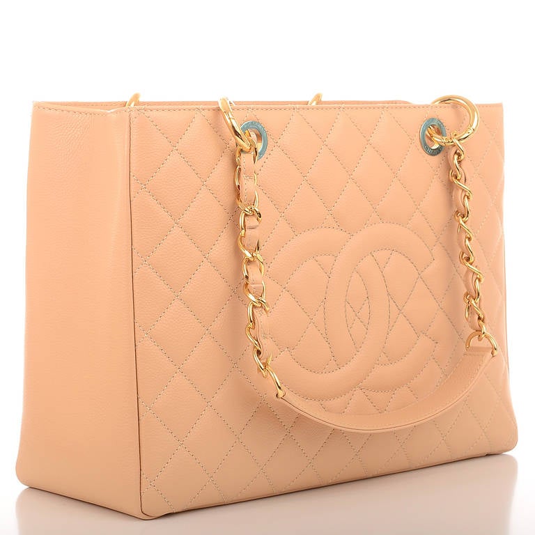 Chanel beige quilted caviar leather Grand Shopper Tote (GST) bag with goldtone hardware, front stitched CC logo, half moon back pocket and double interwoven goldtone chain link and leather padded straps. Interior is lined in beige fabric with front