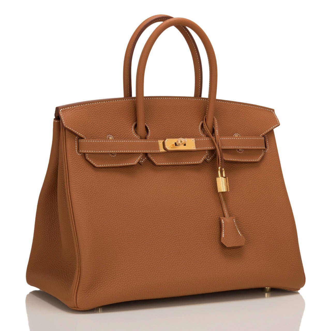 Hermes Gold Birkin 35cm in togo (bull) leather with gold hardware.

This Birkin features white contrast stitching, front toggle closure, clochette with lock and two keys, and double rolled handles.

The interior is lined in Gold chevre with one