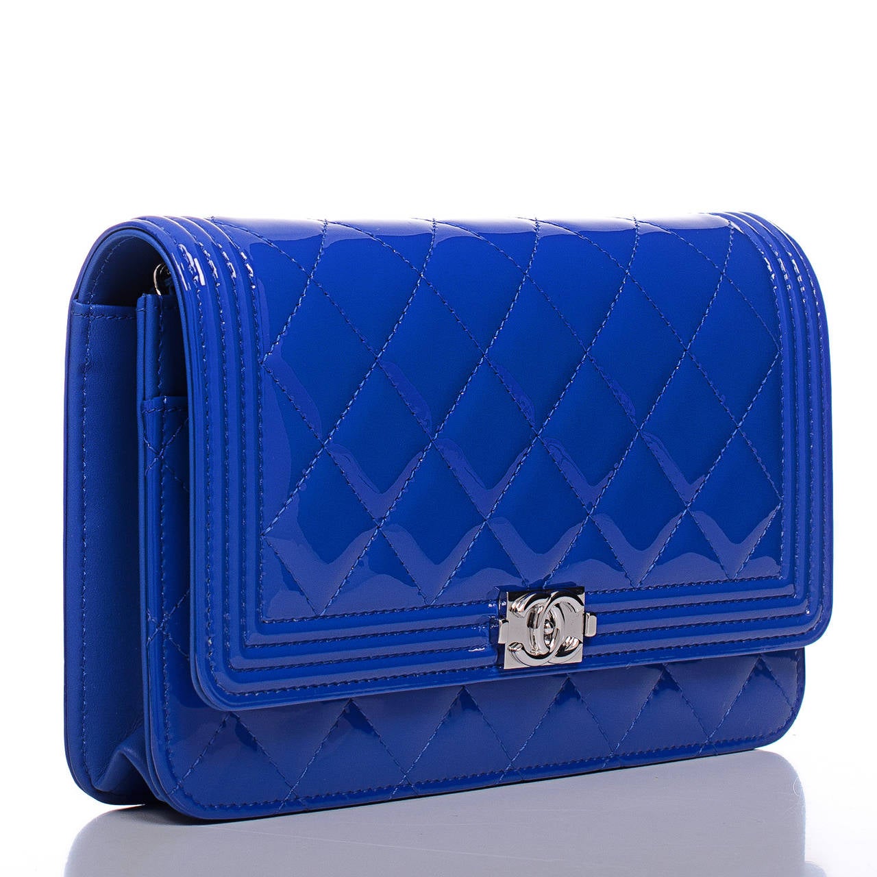 Chanel Boy Wallet On Chain (WOC) of electric blue patent leather with silver tone hardware.

This WOC features a front flap with the signature Le Boy CC charm and hidden snap closure and silver tone metal chain link with blue leather