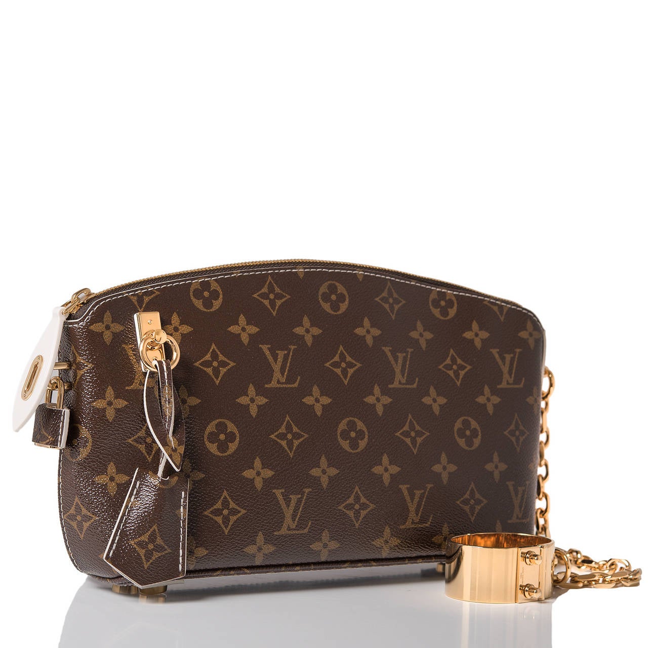 Louis Vuitton limited edition Fetish Lockit Clutch of ultra-glossy Monogram coated canvas (Fetish Canvas) and golden brass hardware.

This clutch features a removable golden brass cuff with chain, clochette and two keys, contrast ivory stitching