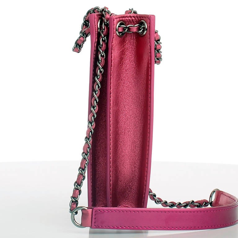 Chanel electric fuchsia pink patent leather mobile cell phone holder.

This runway style features silvertone hardware, front stitched CC logo, expandable metallic pink calfskin sides and bottom, and interwoven silvertone chain link and leather