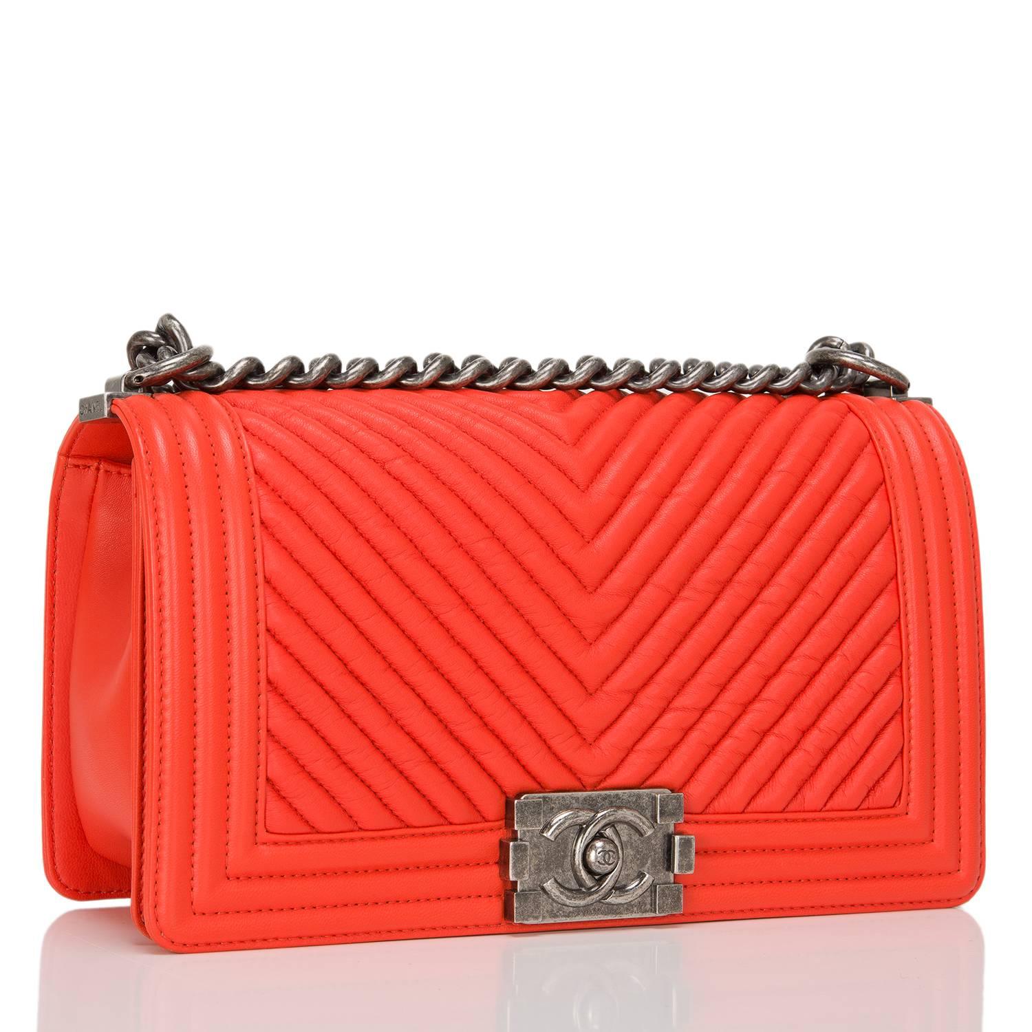 Chanel orange chevron quilted calfskin Medium Boy Bag with aged ruthenium hardware.

This bag features a full front flap with the Boy Chanel signature CC push lock closure and aged ruthenium chain link and orange leather padded shoulder/crossbody