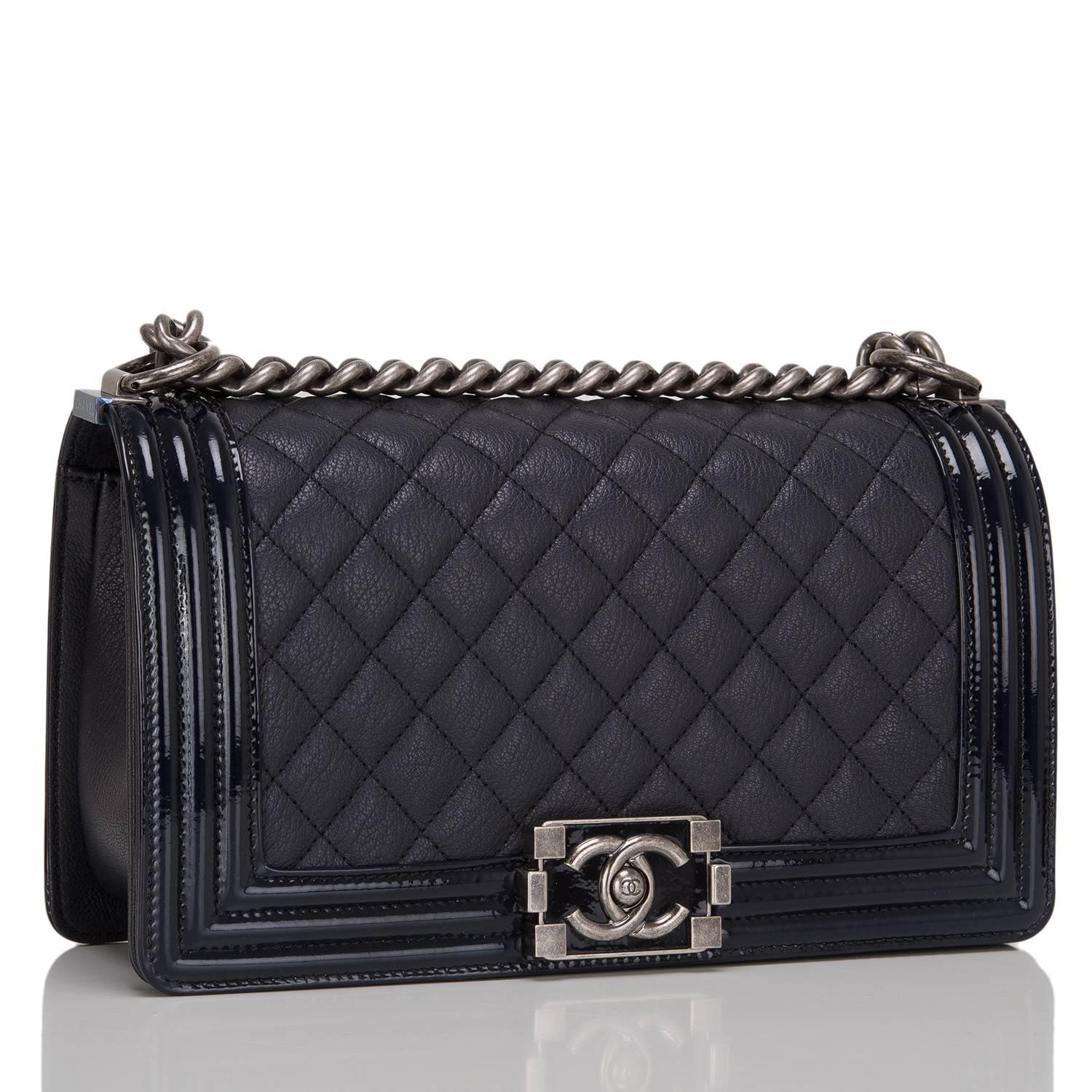  	
Chanel Medium Boy bag of black goatskin (chevre) leather accented with patent leather trim and aged ruthenium hardware.

The bag features a full front flap with a limited edition Le Boy push lock closure of a glossy black lacquer and ruthenium
