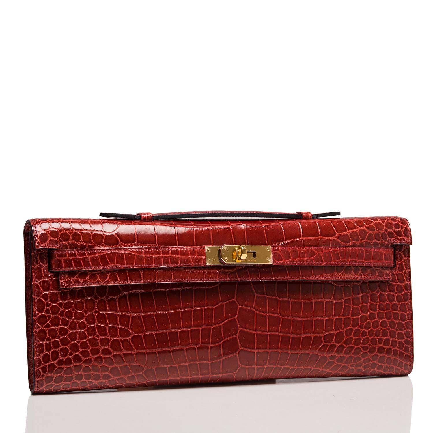  	
Hermes Rouge H Kelly Cut in shiny Porosus Crocodile with gold hardware.

This exotic Kelly Cut has tonal stitching, front straps with toggle closure and a top flat handle.

The interior is lined in Rouge H chèvre leather and features an