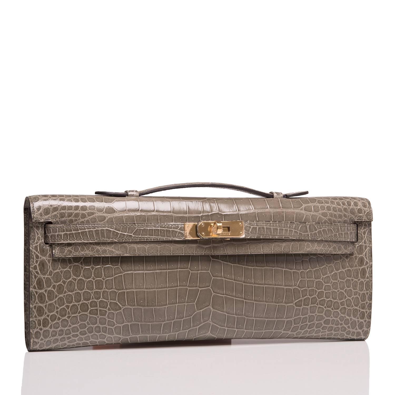 Hermes Gris Tourterelle (Gris T) shiny porosus crocodile Kelly Cut with gold hardware.

This Kelly Cut has tonal stitching, front straps with toggle closure and a top flat handle.

The interior is lined in Gris T chèvre leather and features an